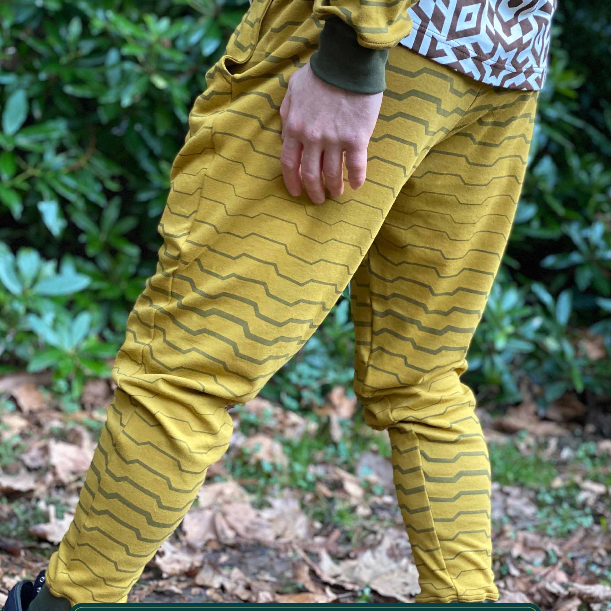 Organic cotton unisex joggers, yellow fabric with brown geometric print, back left side view on male model.