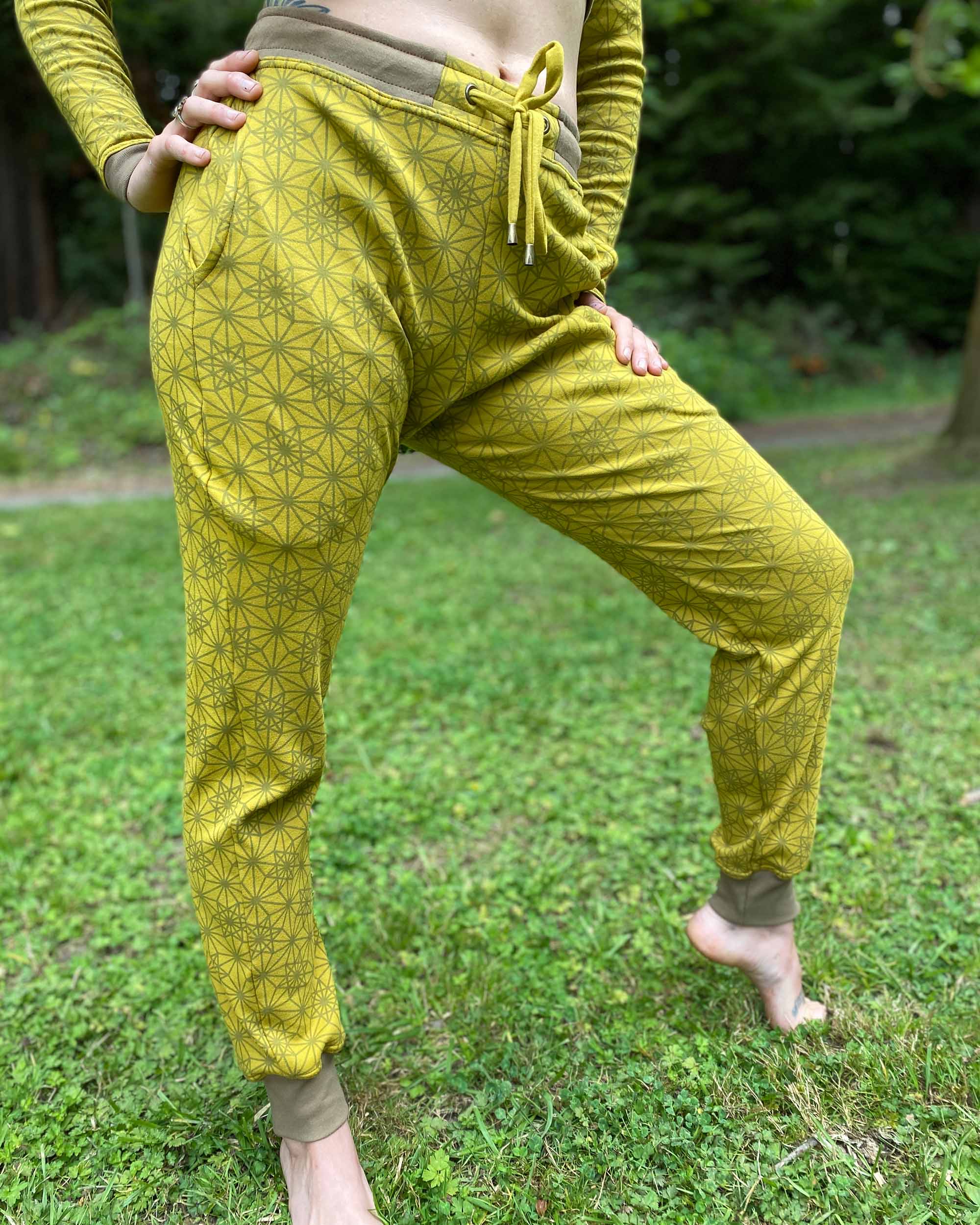 Organic cotton unisex joggers, yellow fabric with geometric print, right side view on female model.