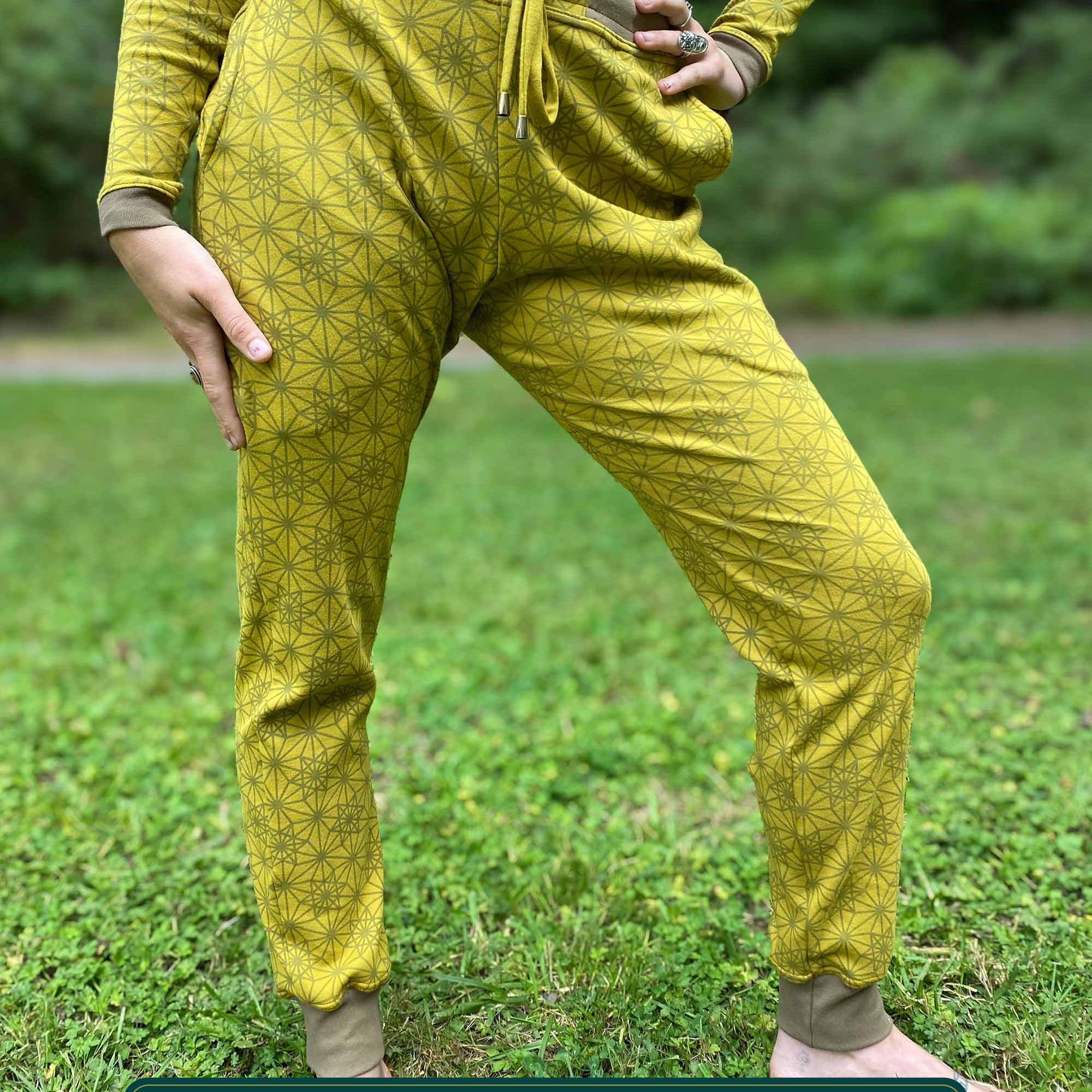 Organic cotton unisex joggers, yellow fabric with geometric print, front view on female model.