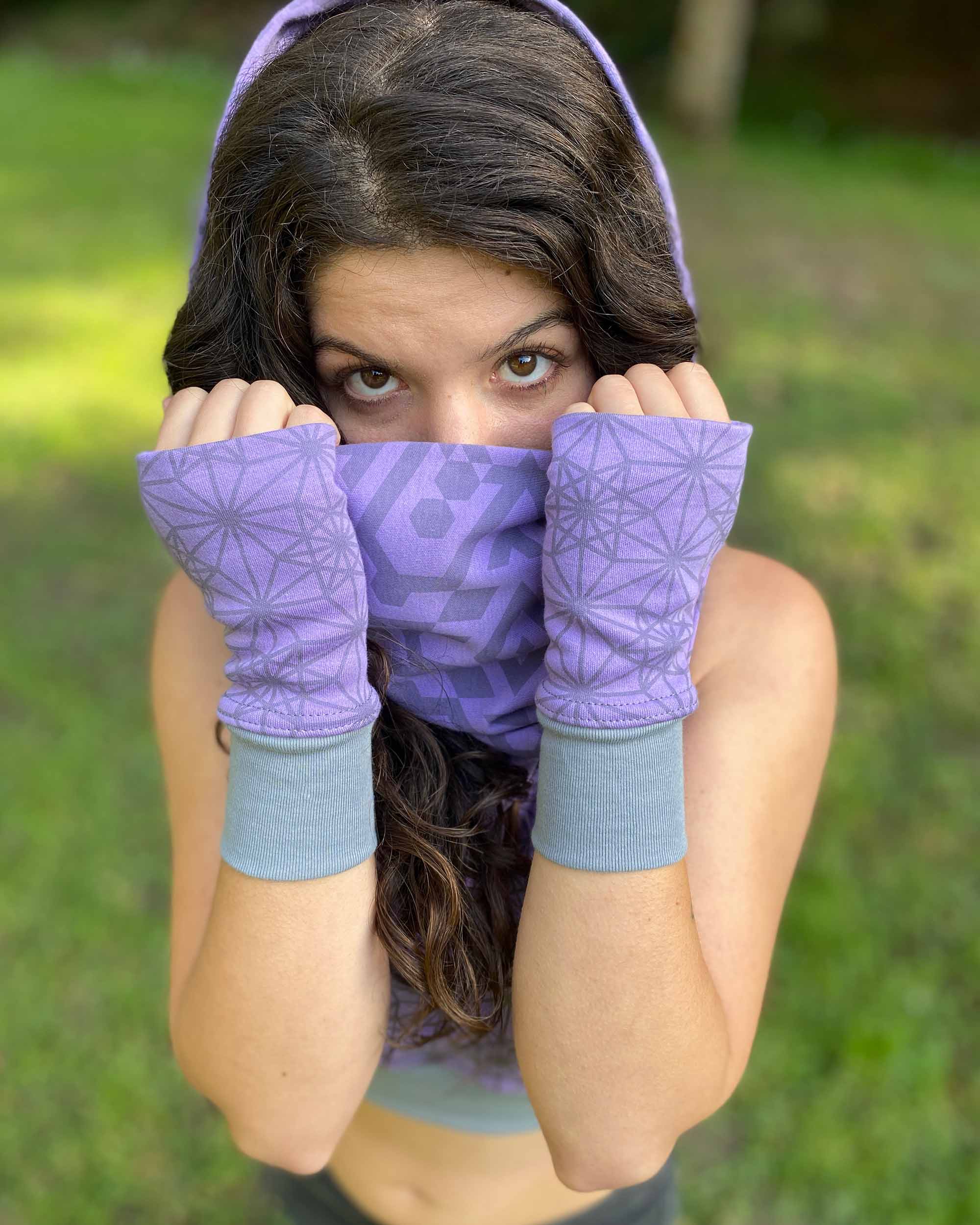 Organic cotton hand warmers, lavender fabric with geometric print, front view female model in nature.