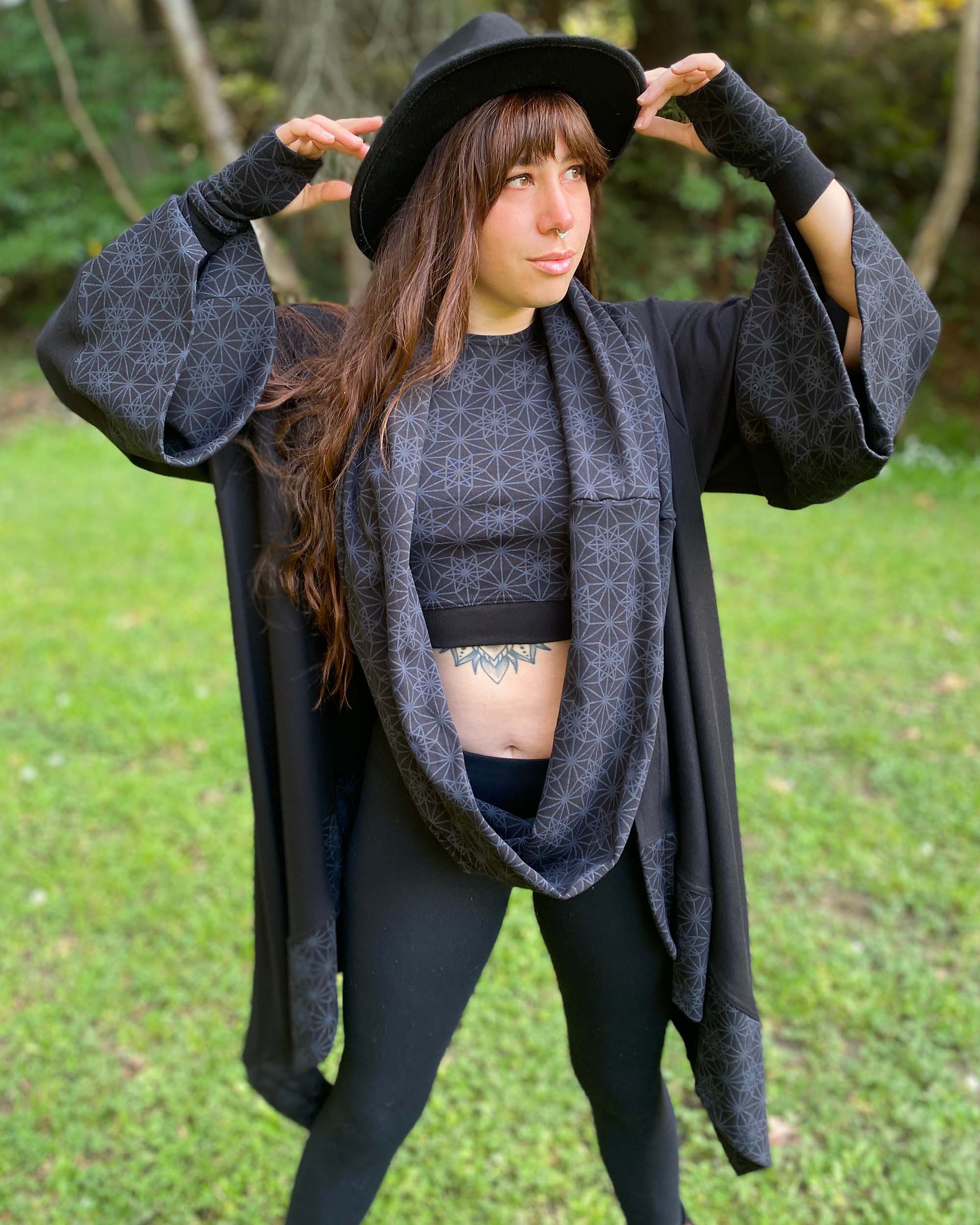 Organic cotton infinity scarf, black fabric with sacred geometry print, full matching look on female model.