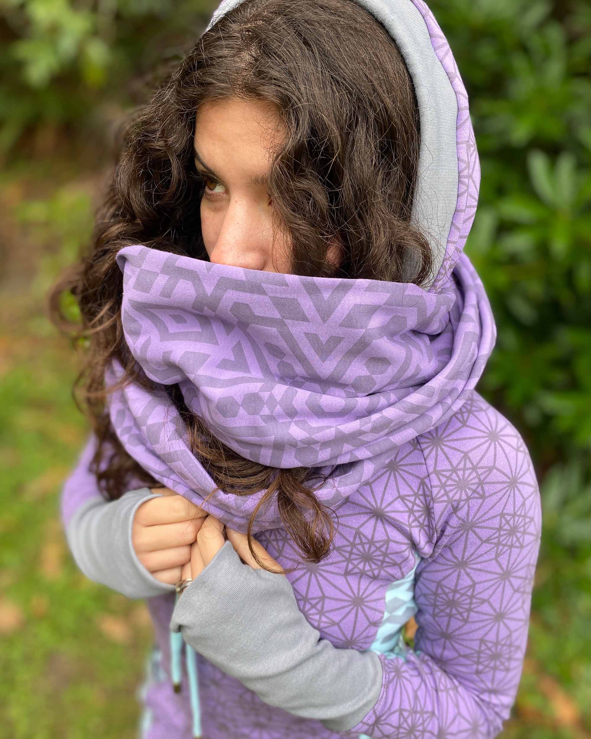 Organic cotton infinity scarf, lavender fabric with geometric print, front top view on female model.