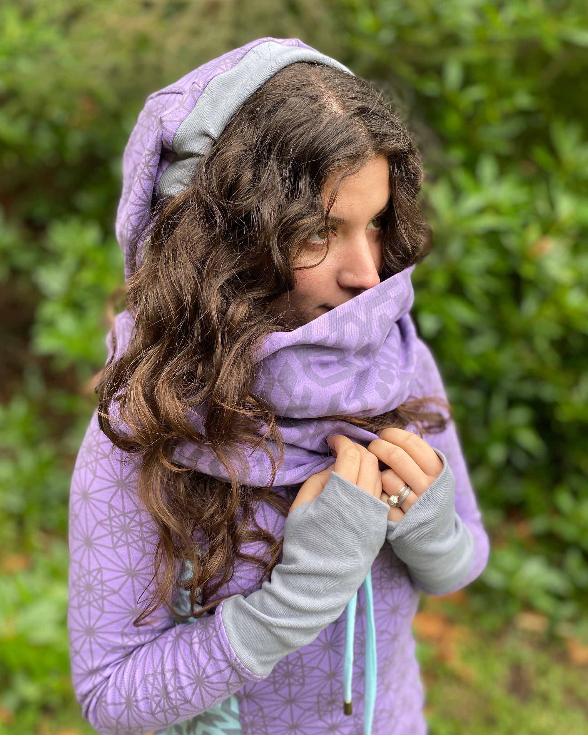 Organic cotton infinity scarf, lavender fabric with geometric print, right side view on female model.