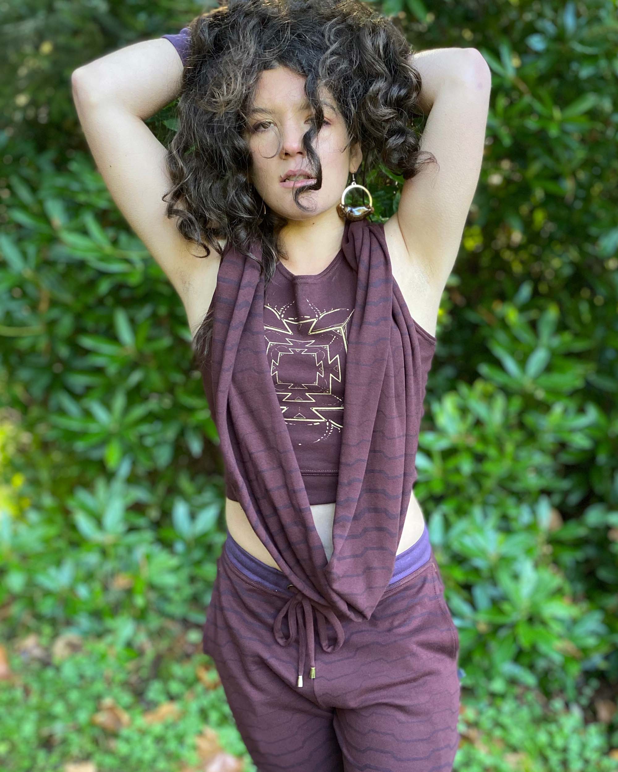 Organic cotton infinity scarf, brown fabric with geometric stripes, front view on female model.