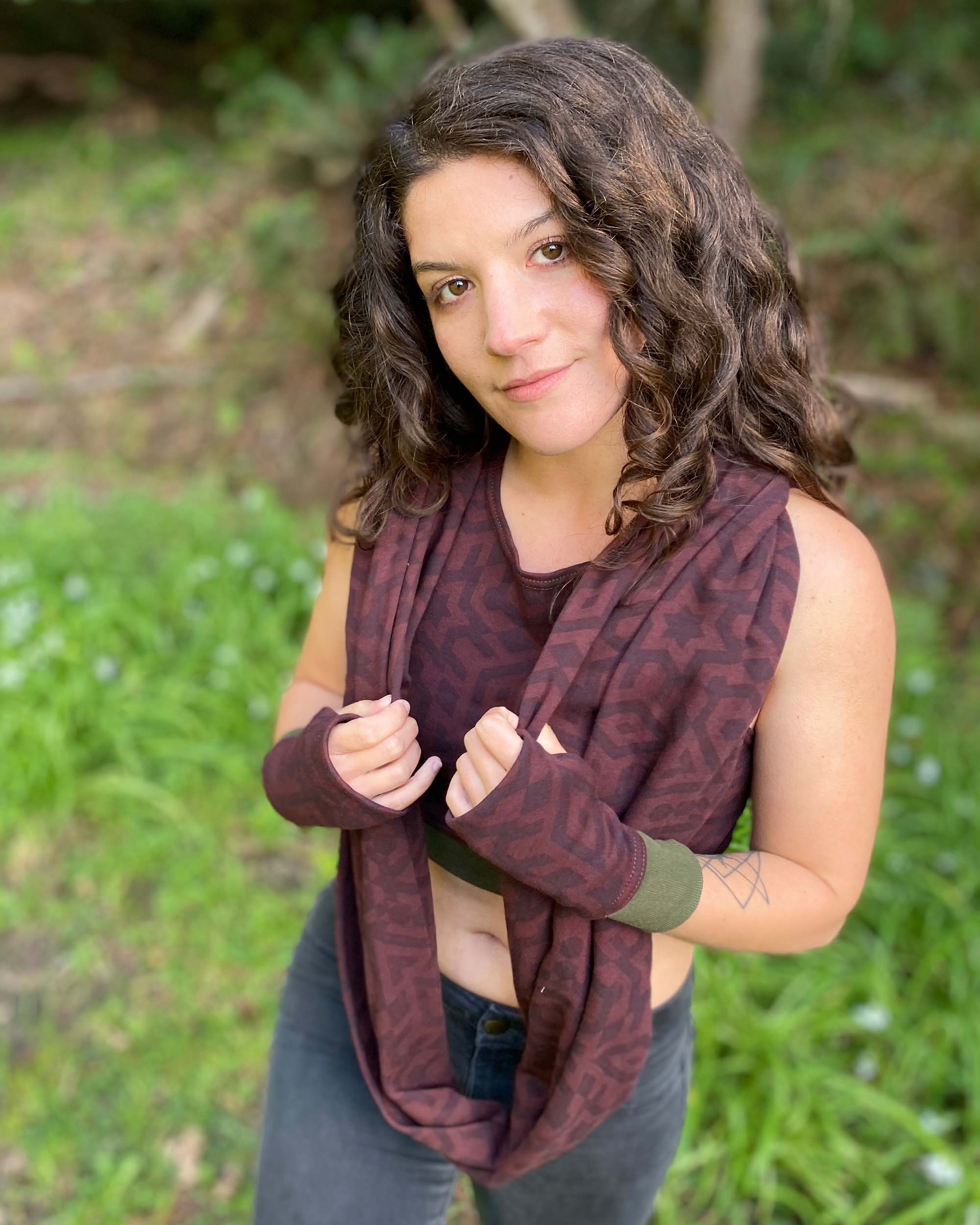 Organic cotton infinity scarf, brown fabric with geometric print, front view on female model.
