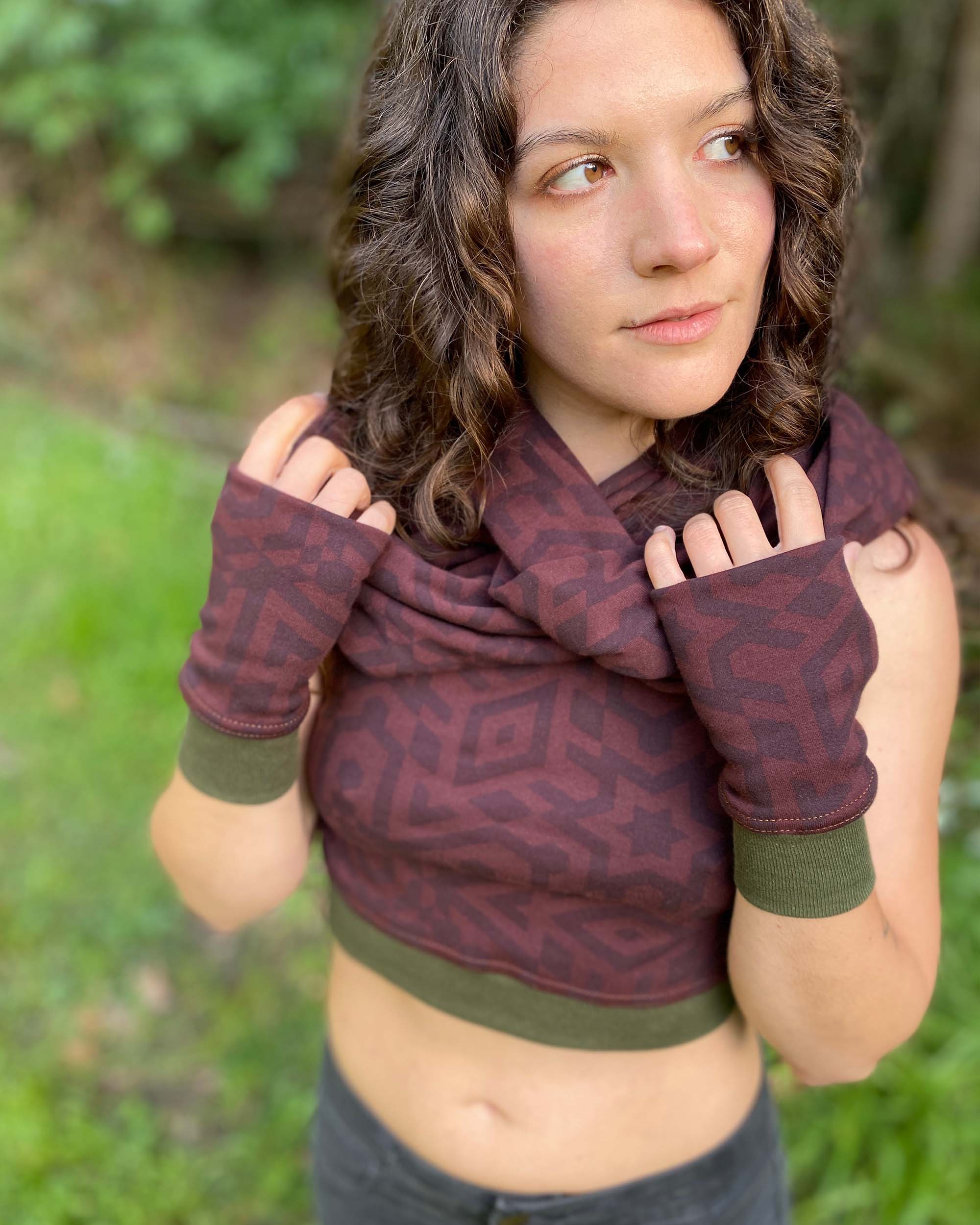 Organic cotton infinity scarf, brown fabric with geometric print, close up view on female model.