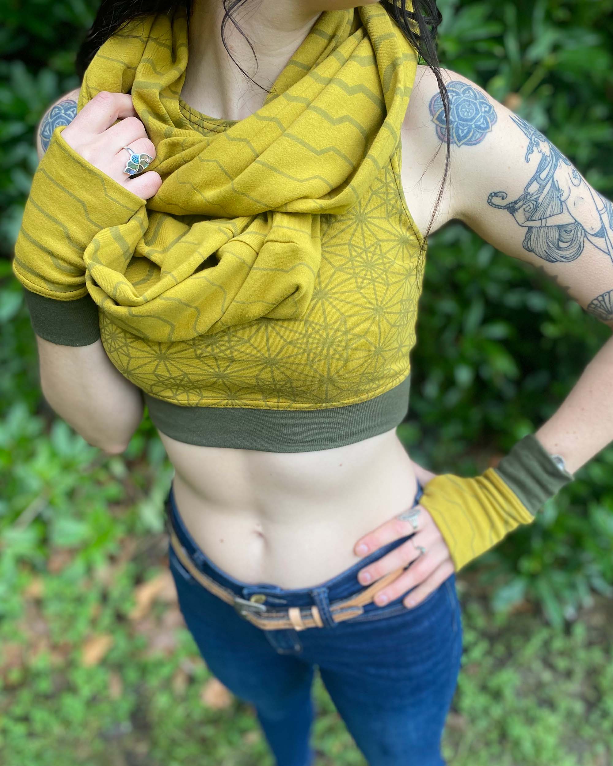 Organic cotton infinity scarf, yellow fabric with geometric stripes, front view worn by  female model.