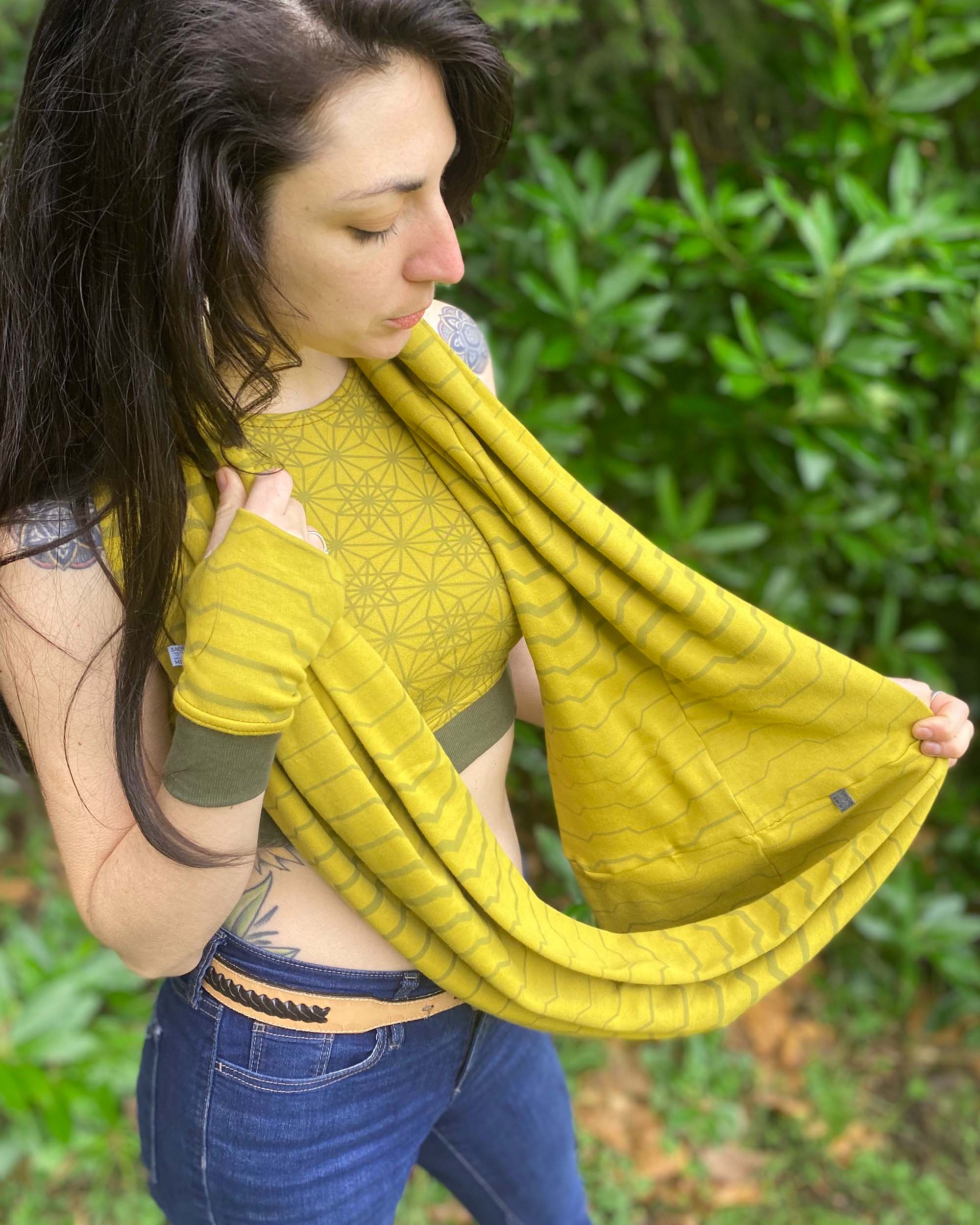 Organic cotton infinity scarf, yellow fabric with geometric stripes, top right view on female model.