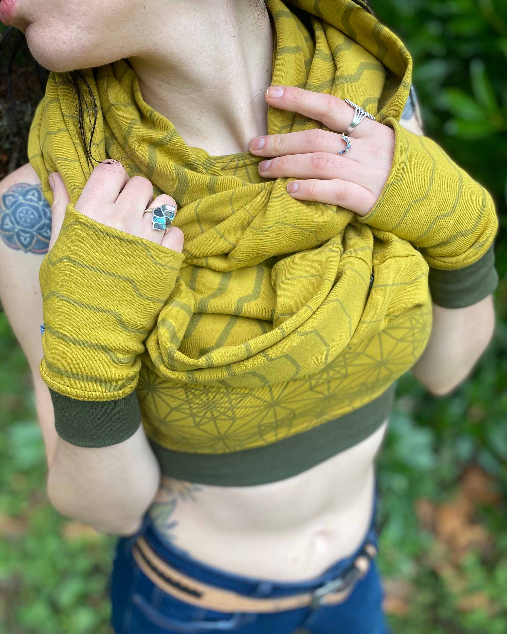 Female model wearing matching set of crop top, infinity scarf and fingerless gloves, yellow organic cotton fabric with stripes, detail view.