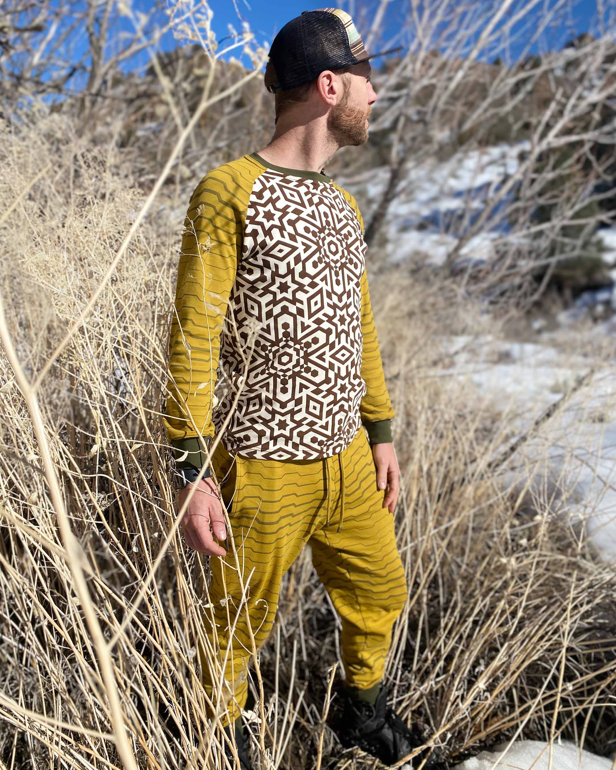 Men's matching 2 piece set, joggers and long sleeve shirt, yellow with geometric stripe accents, side view on male model.