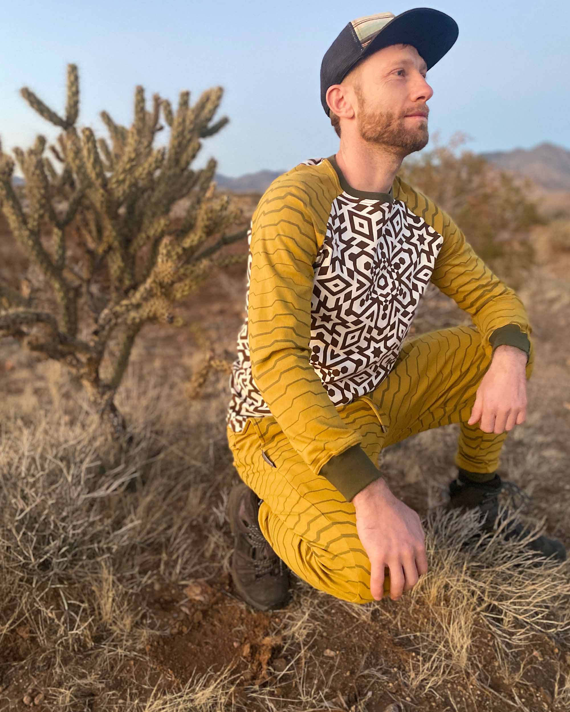 Men's matching 2 piece set, joggers and long sleeve shirt, yellow with geometric stripe accents, front right side view on crouching model.