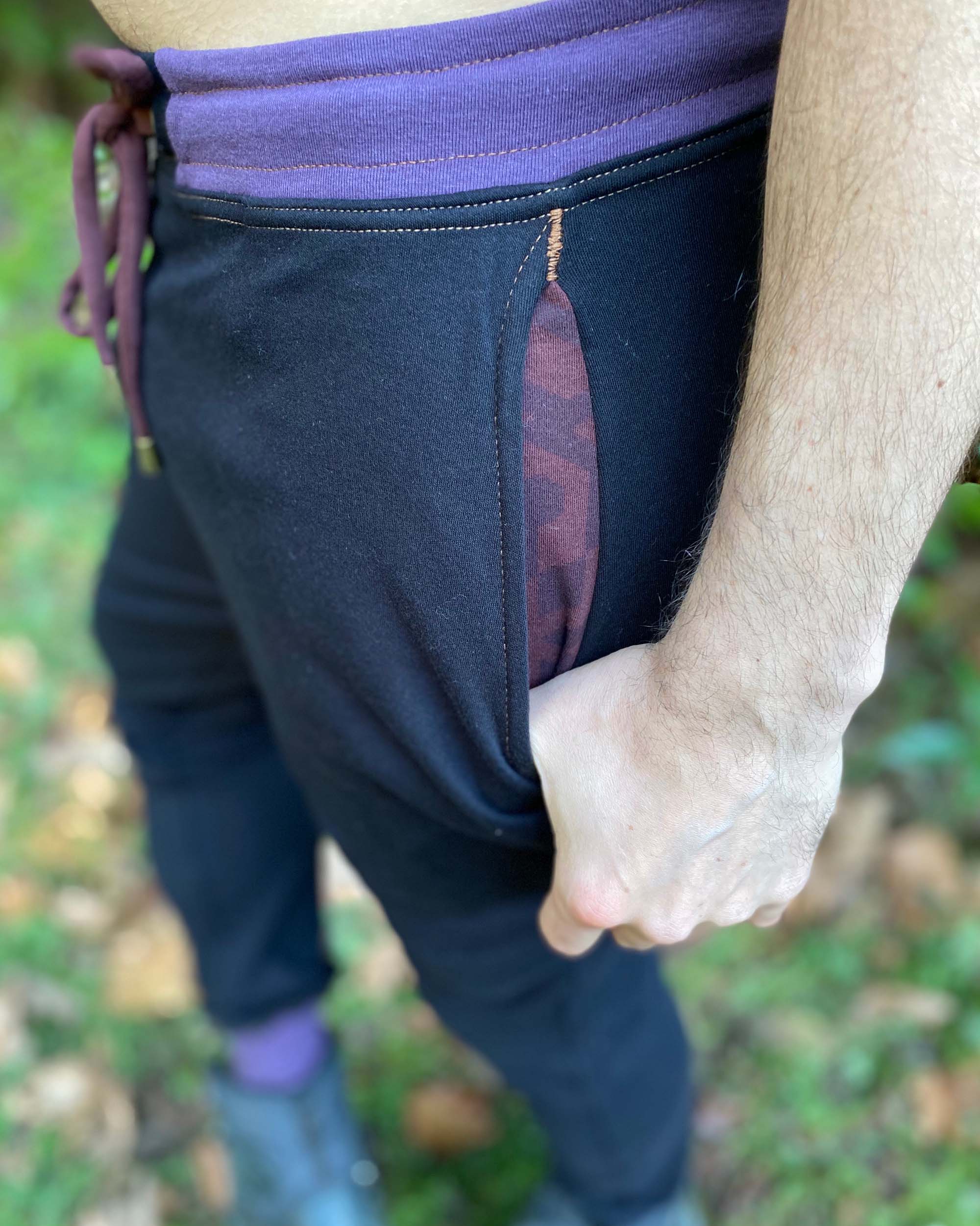 Organic cotton knit joggers, black with brown and purple accents, detail view of pocket stitching.