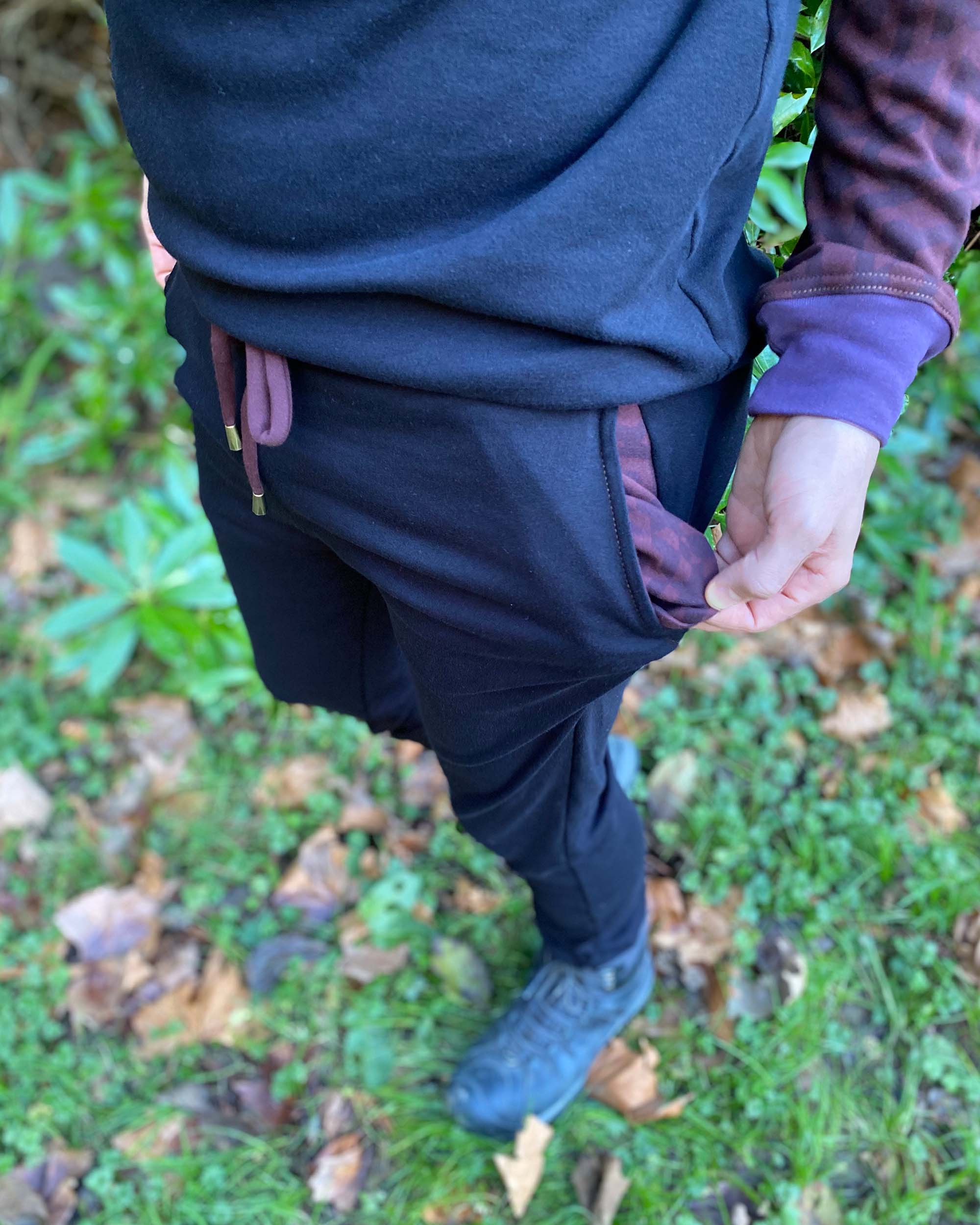 Organic cotton knit joggers, black with brown and purple accents, detail view of pocket lining.