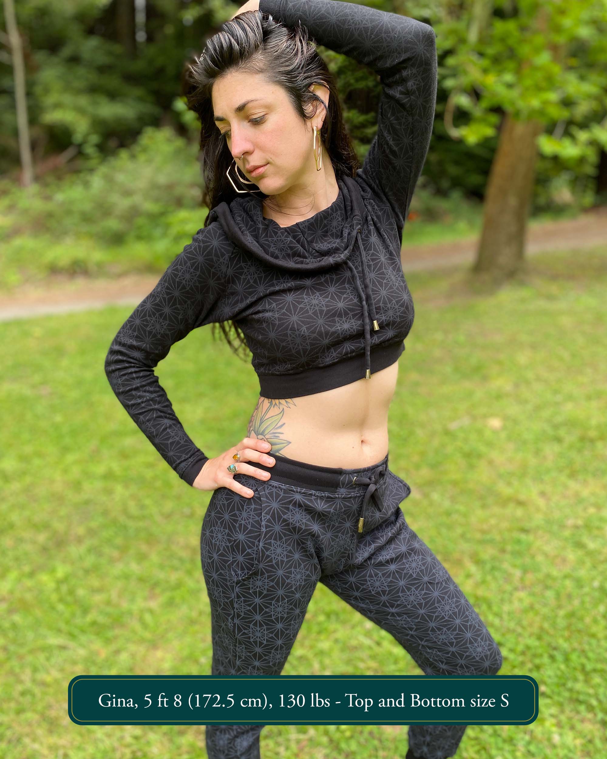 Women's matching two piece outfit, joggers and crop hoodie, black fabric with geometric print, front view on model.