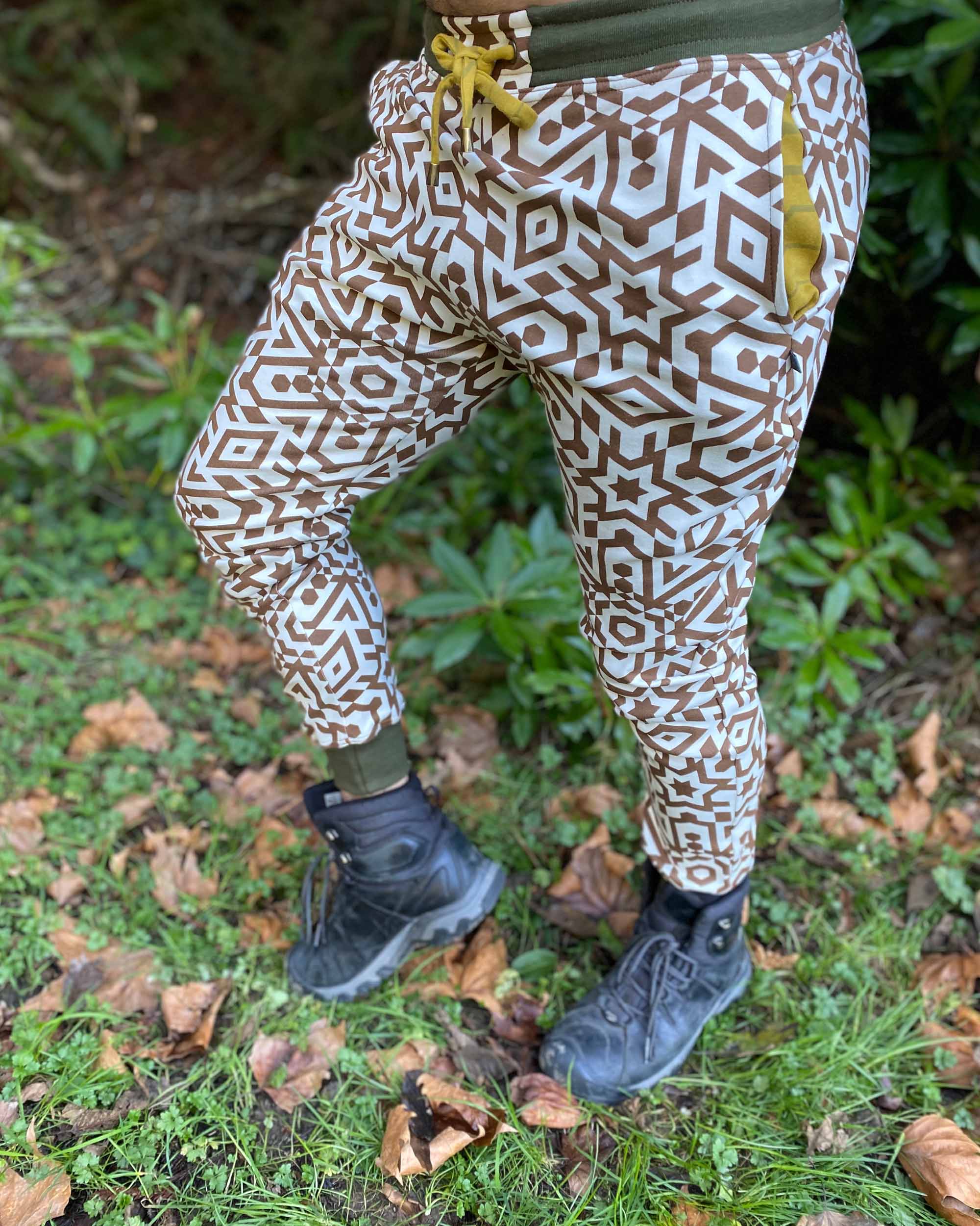 Organic cotton joggers, undyed with brown geometric print, front left side view on male model.