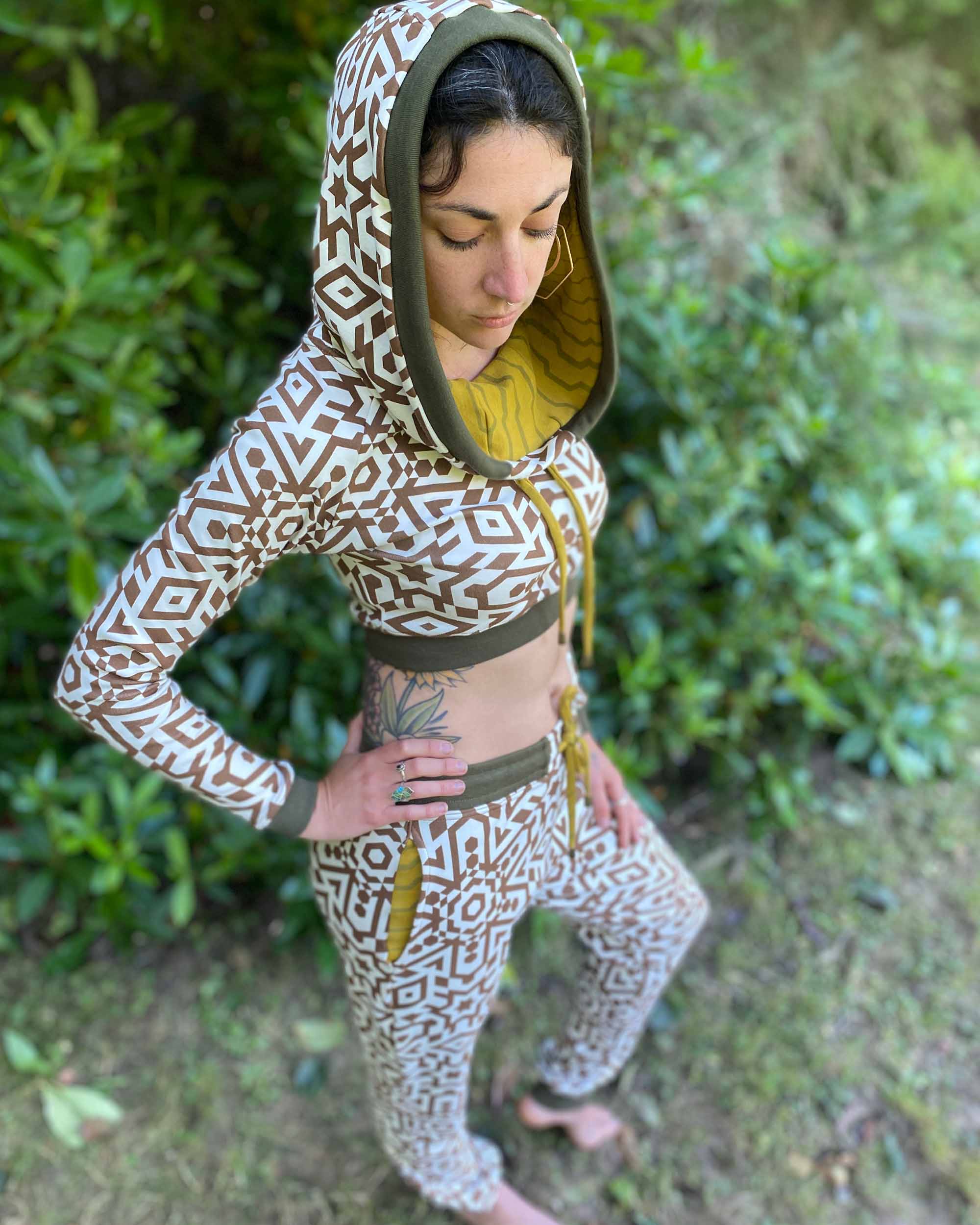 Matching two piece outfit, joggers and crop hoodie, undyed with brown geometric print, full length view on model.