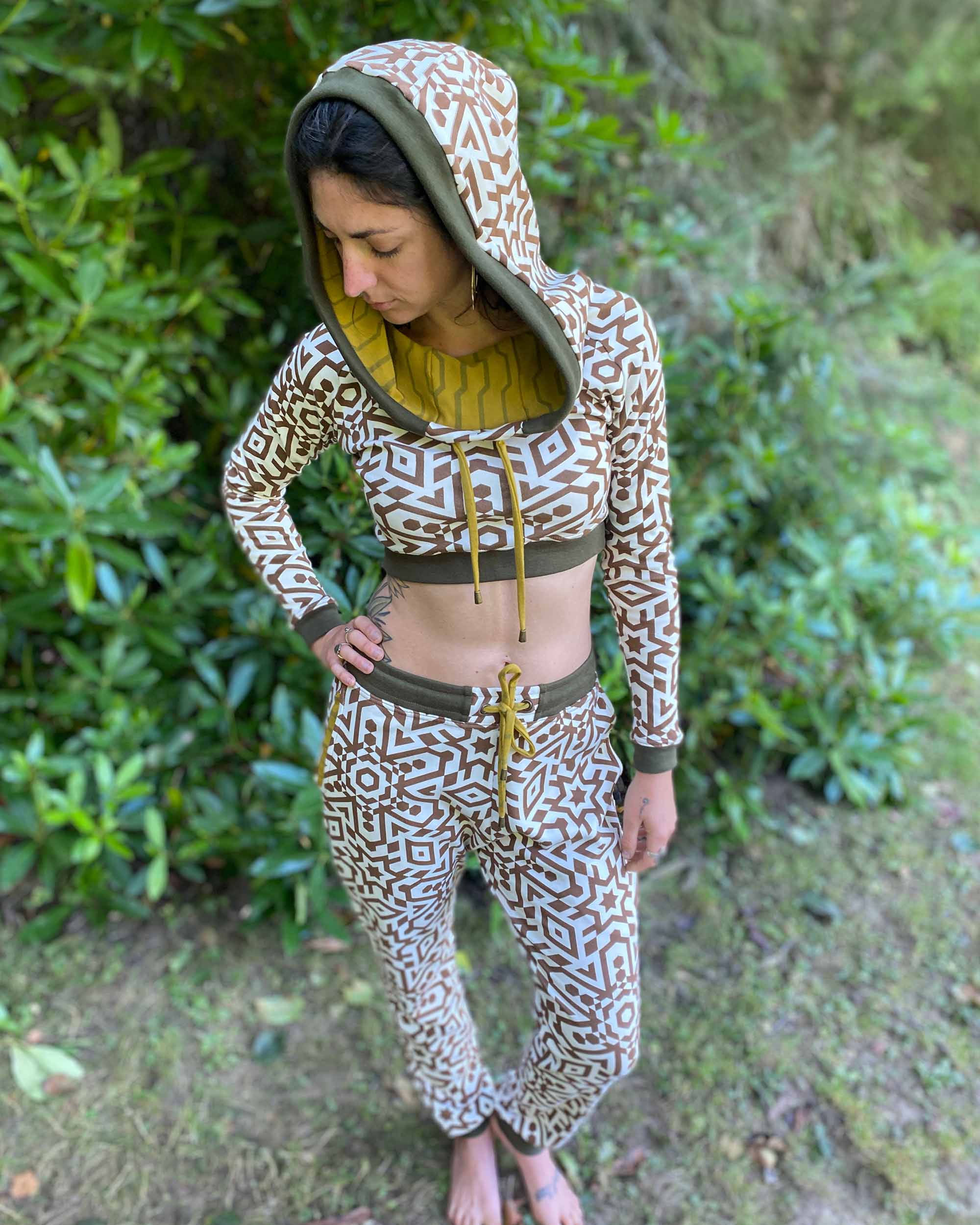 Women's matching two piece set, joggers and crop hoodie, undyed with brown geometric print, left side view on model.