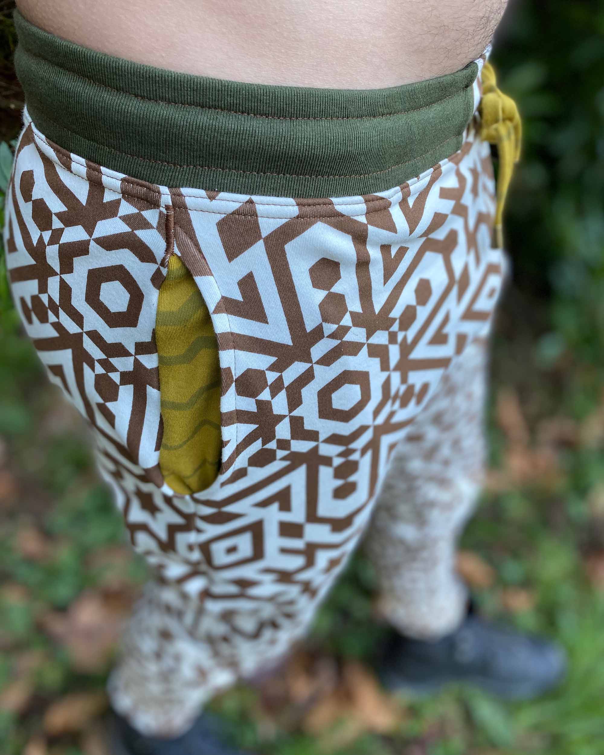 Organic cotton joggers, undyed with brown geometric print, close up view of pocket fabric.