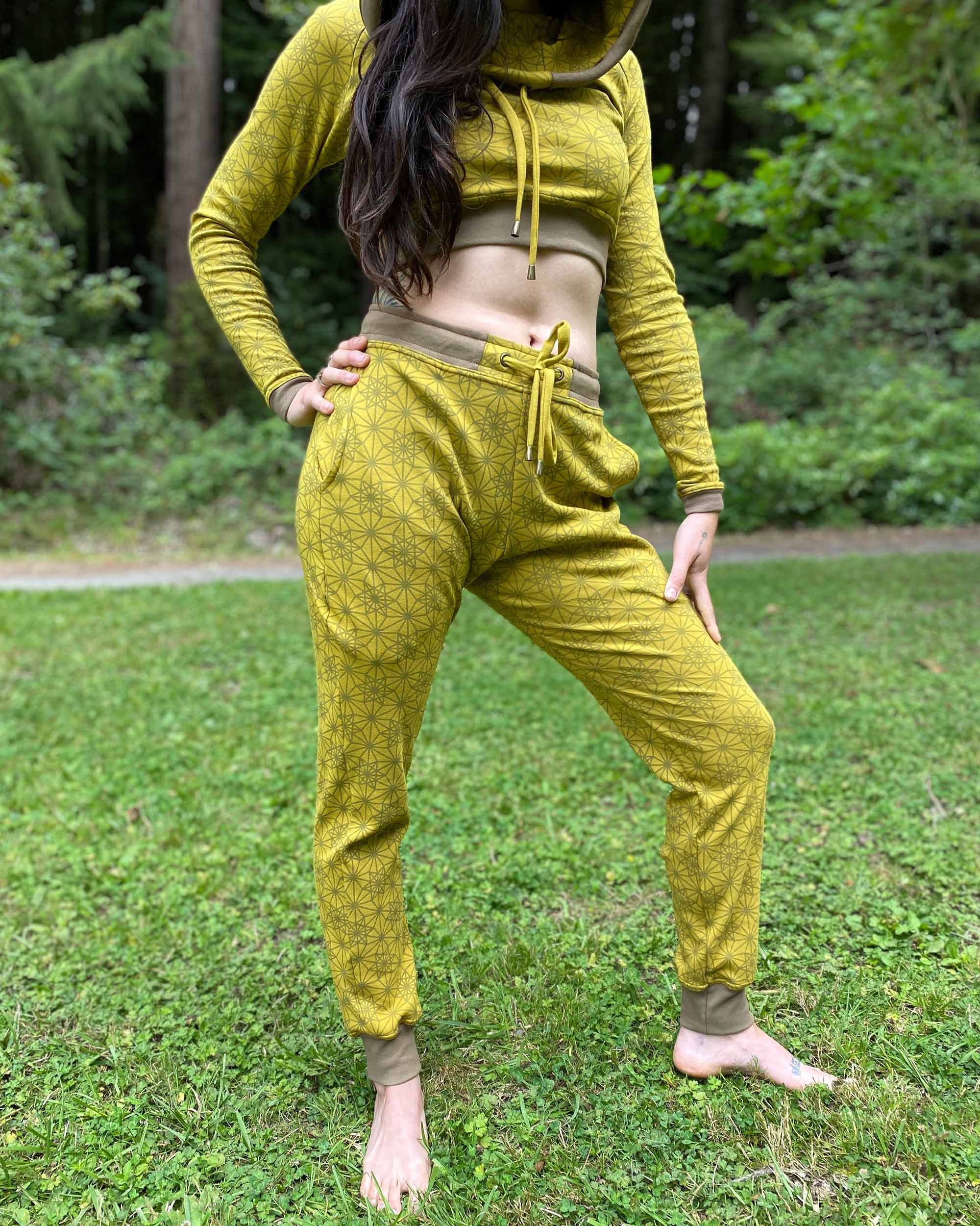 Women's matching two piece outfit, joggers and crop hoodie, yellow fabric with geometric print, front view on model.