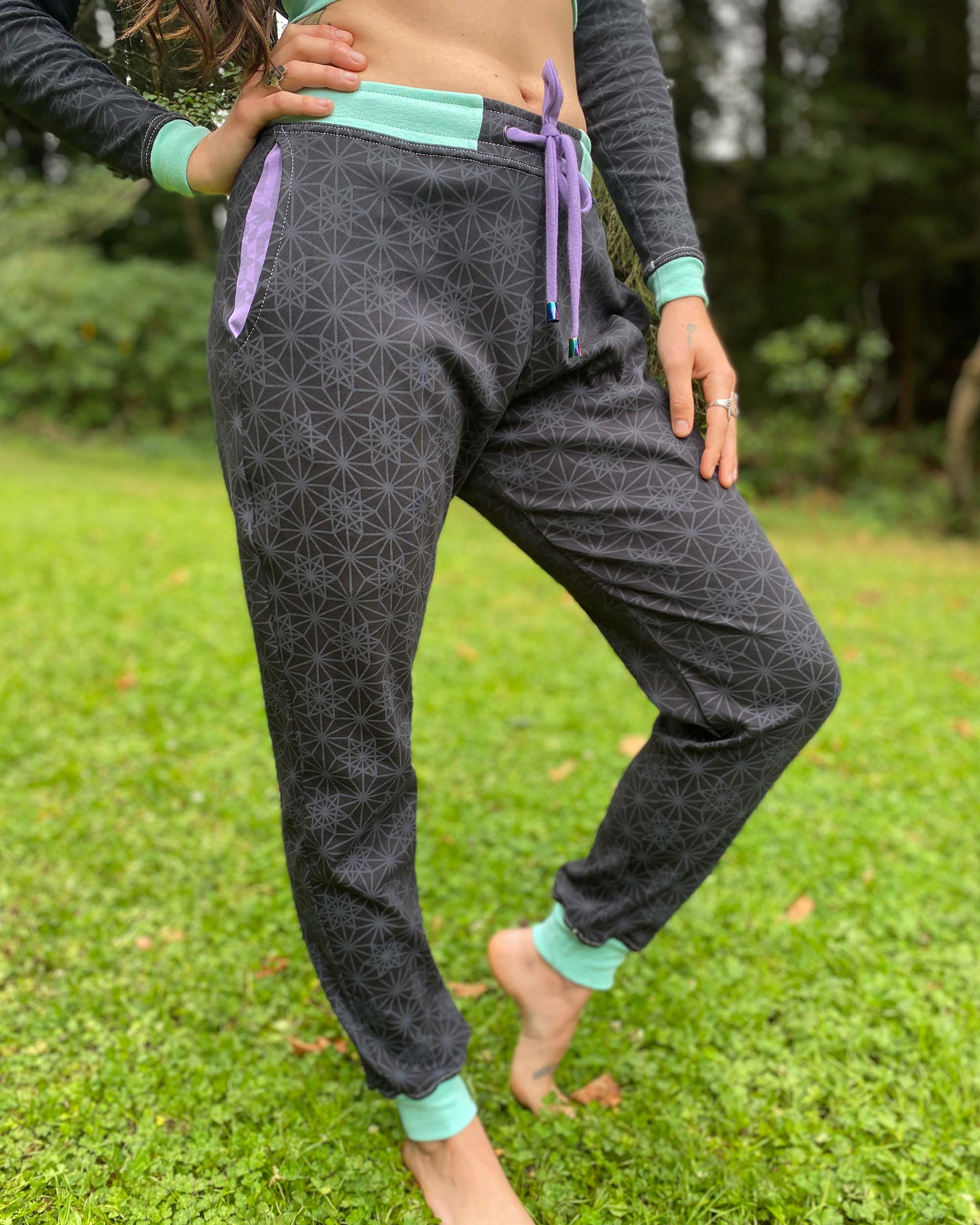 Organic cotton joggers, black and lavender fabric with geometric print, front view on model.