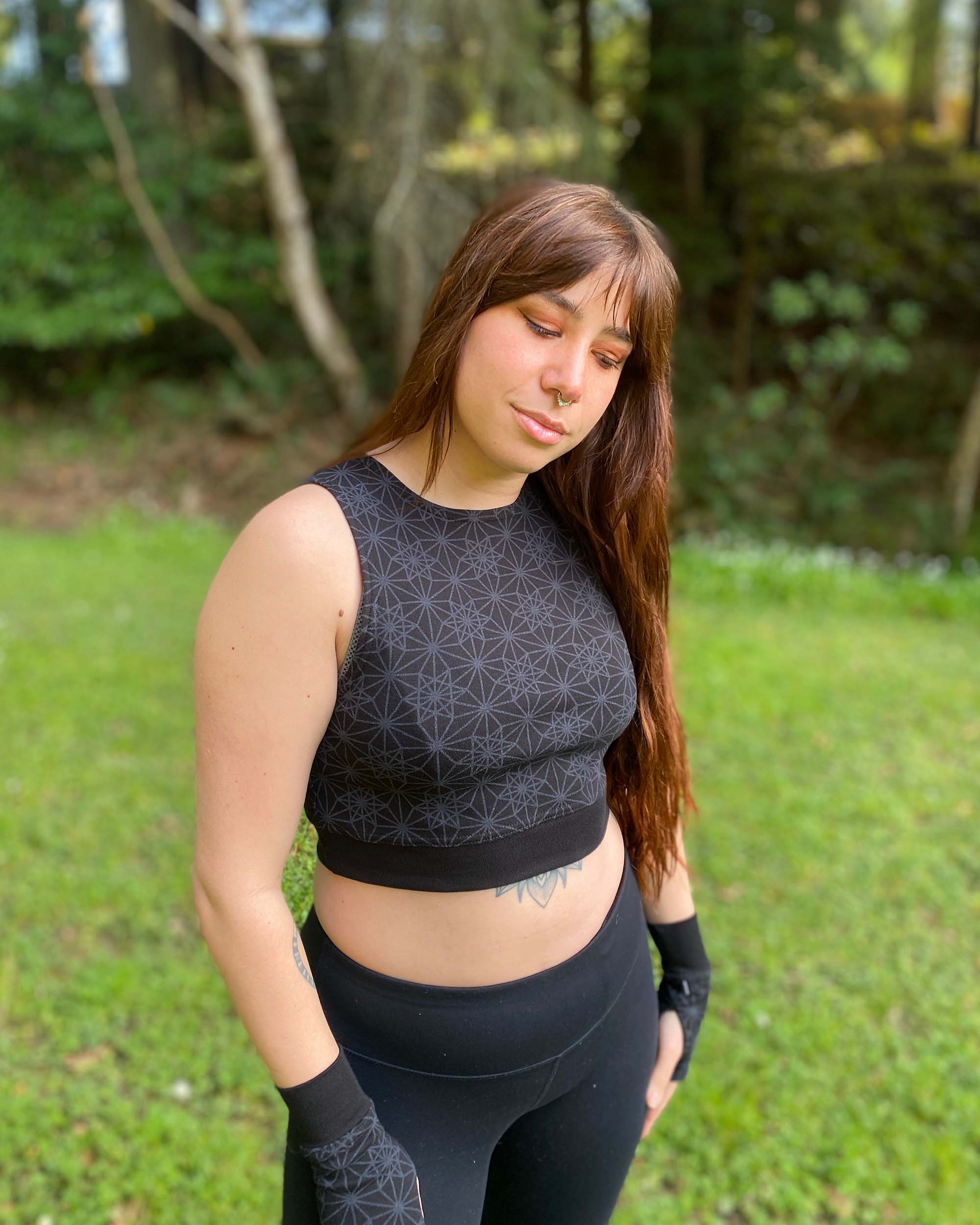 Organic cotton crop top, black fabric with grey geometric print, front view on female model.