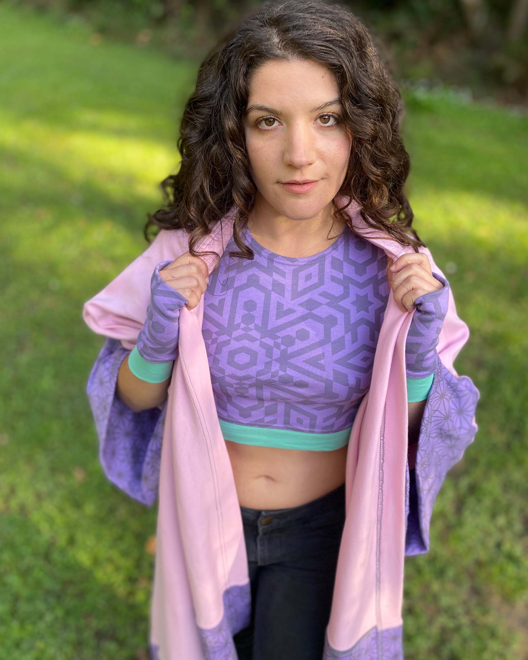 Organic cotton crop top, lavender fabric with sacred geometry print, front view on female model in nature.