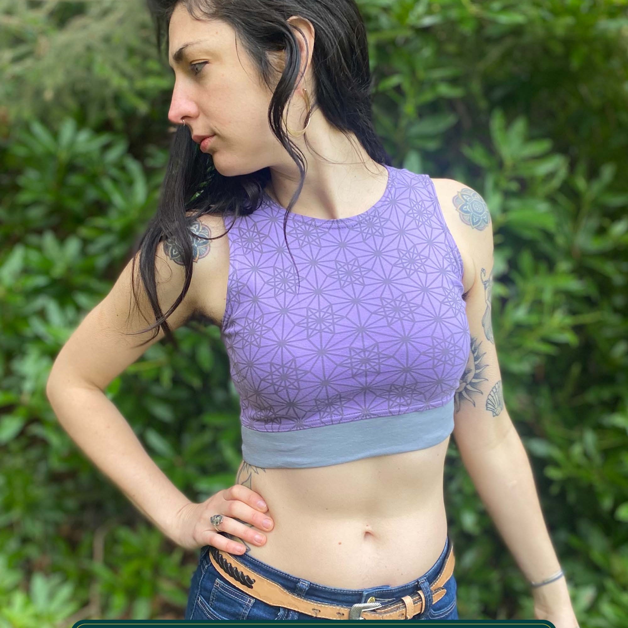 Organic cotton crop top, lavender fabric with sacred geometry print, front right view on slender female model.