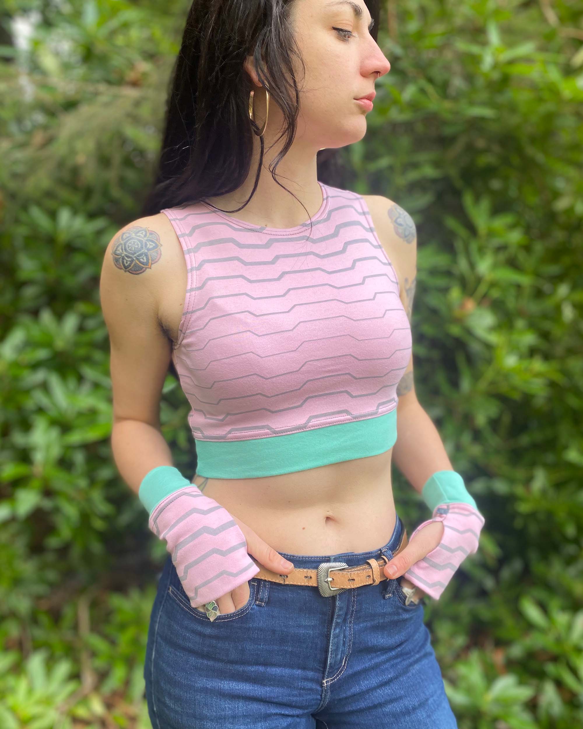 Organic cotton crop top, pink fabric with grey geometric print, front right side view on model.