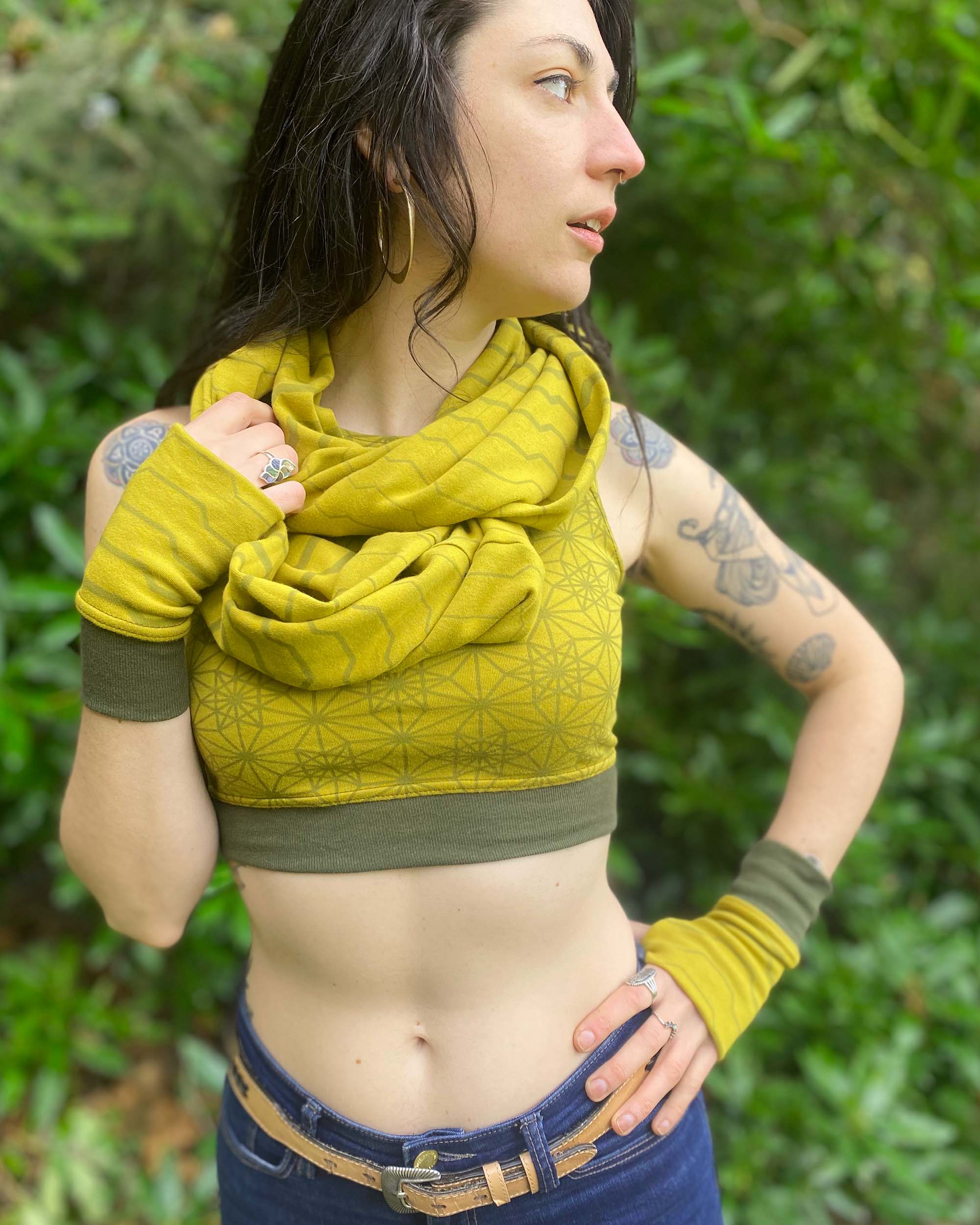 Organic cotton crop top, yellow fabric with sacred geometry print and green accent fabric, front close up view.
