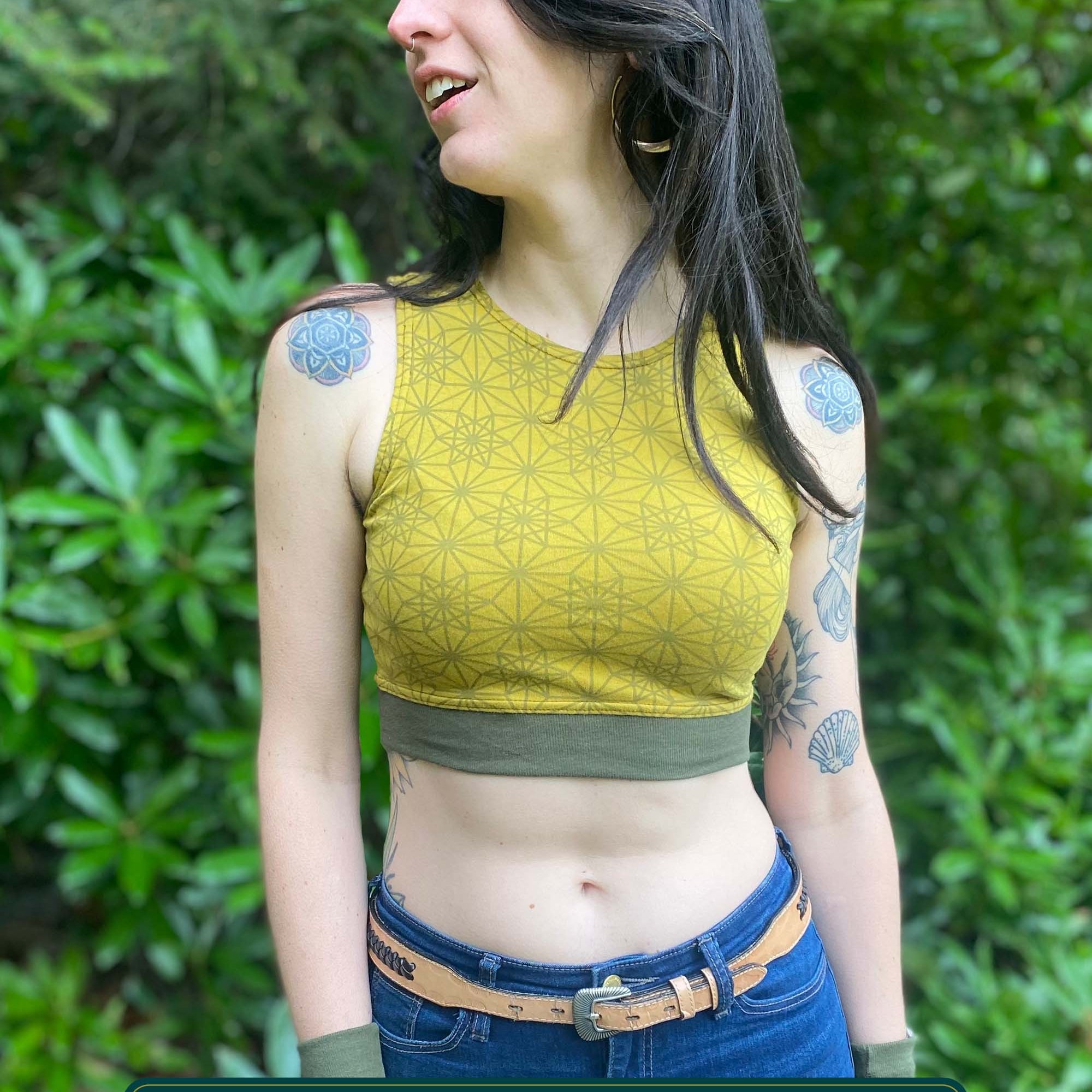 Organic cotton crop top, yellow fabric with sacred geometry print and green accent fabric, front view.