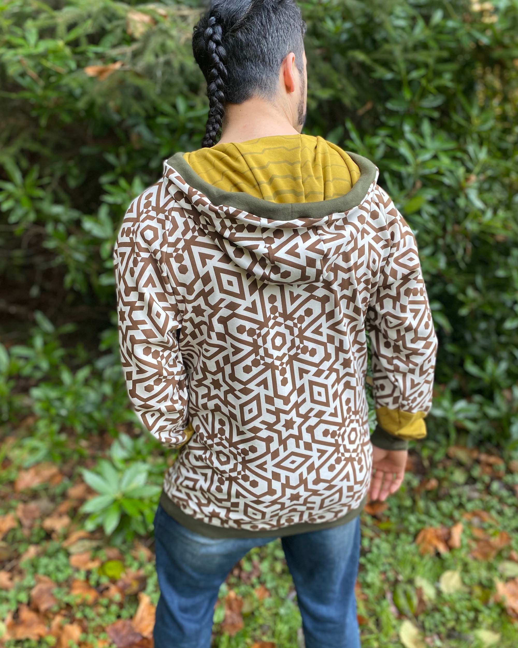Organic cotton hoodie, un-dyed fabric with brown geo print, back view on male model.