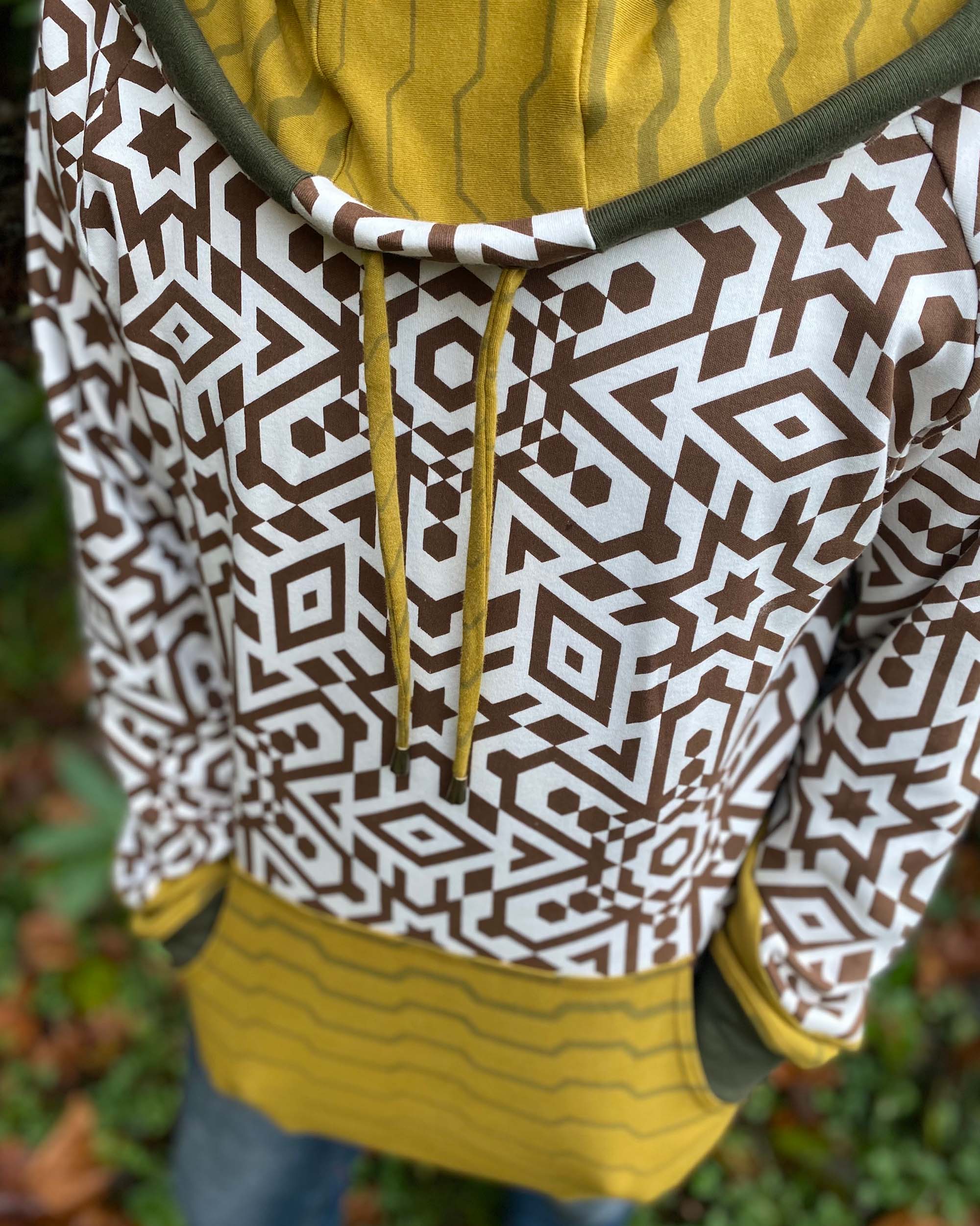 Organic cotton hoodie, un-dyed fabric with brown geo print, detail front view of fabric.