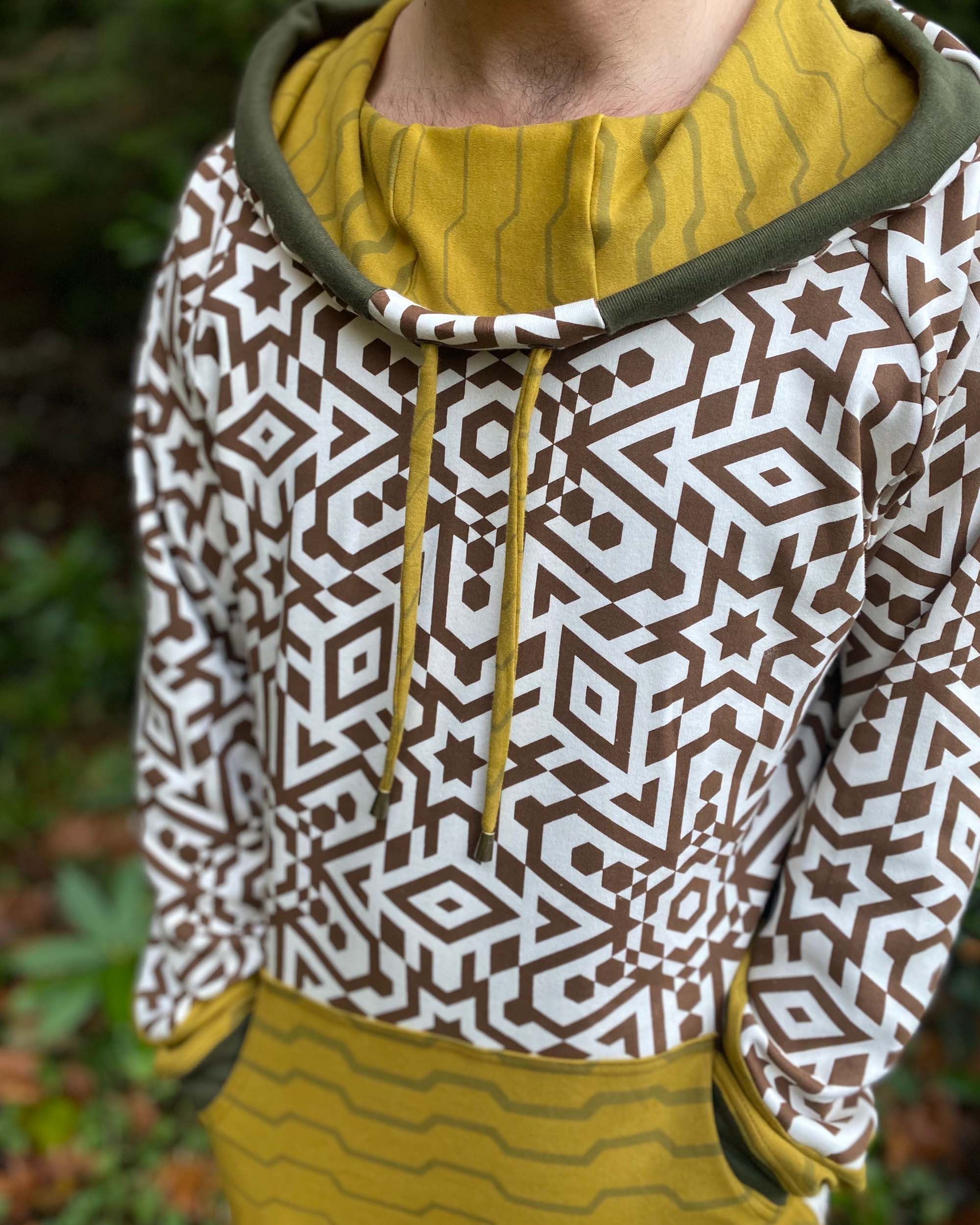 Organic cotton hoodie, un-dyed fabric with brown geometric print, detail view of fabric.