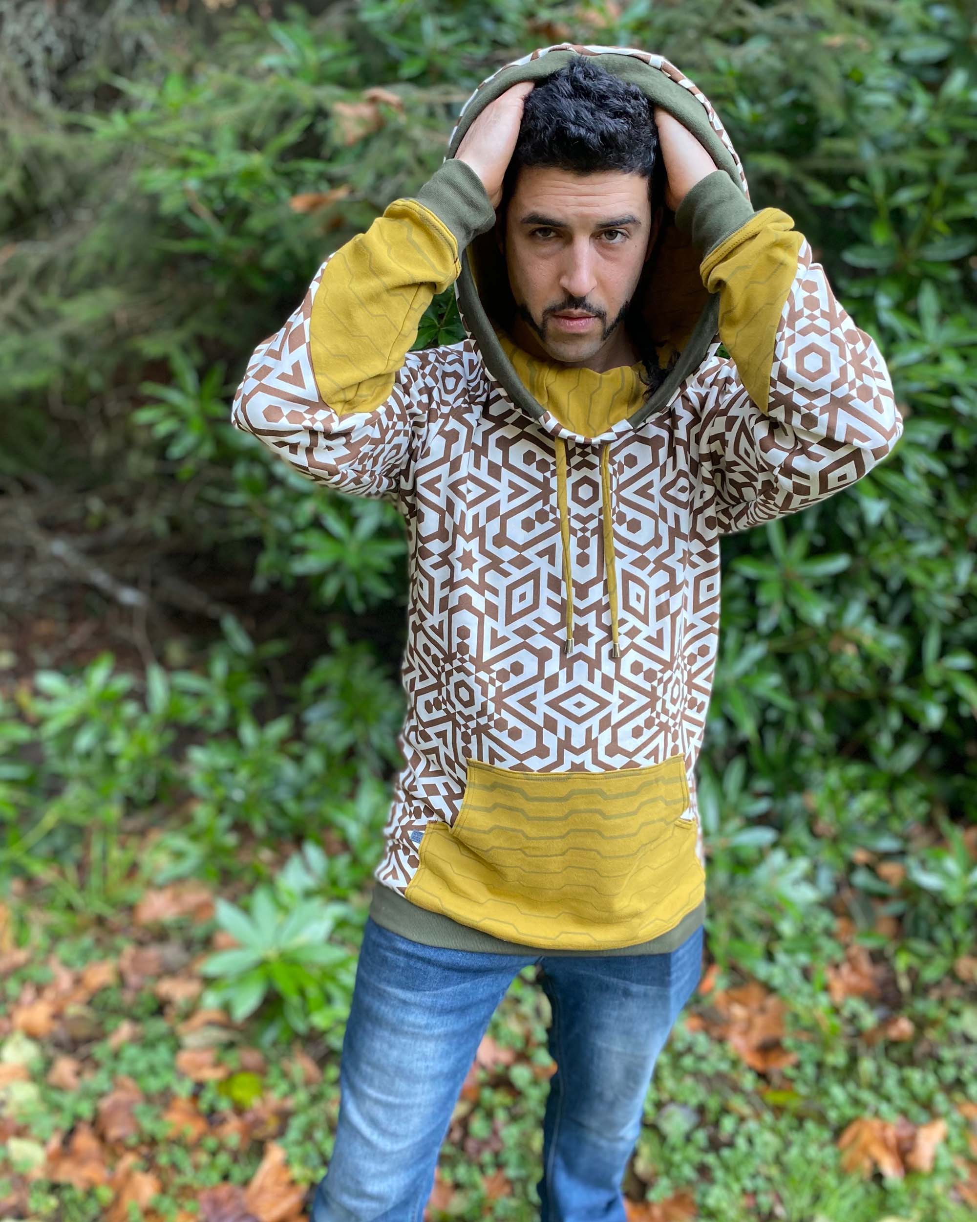 Organic cotton hoodie, un-dyed fabric with brown geometric print, front view on male model.