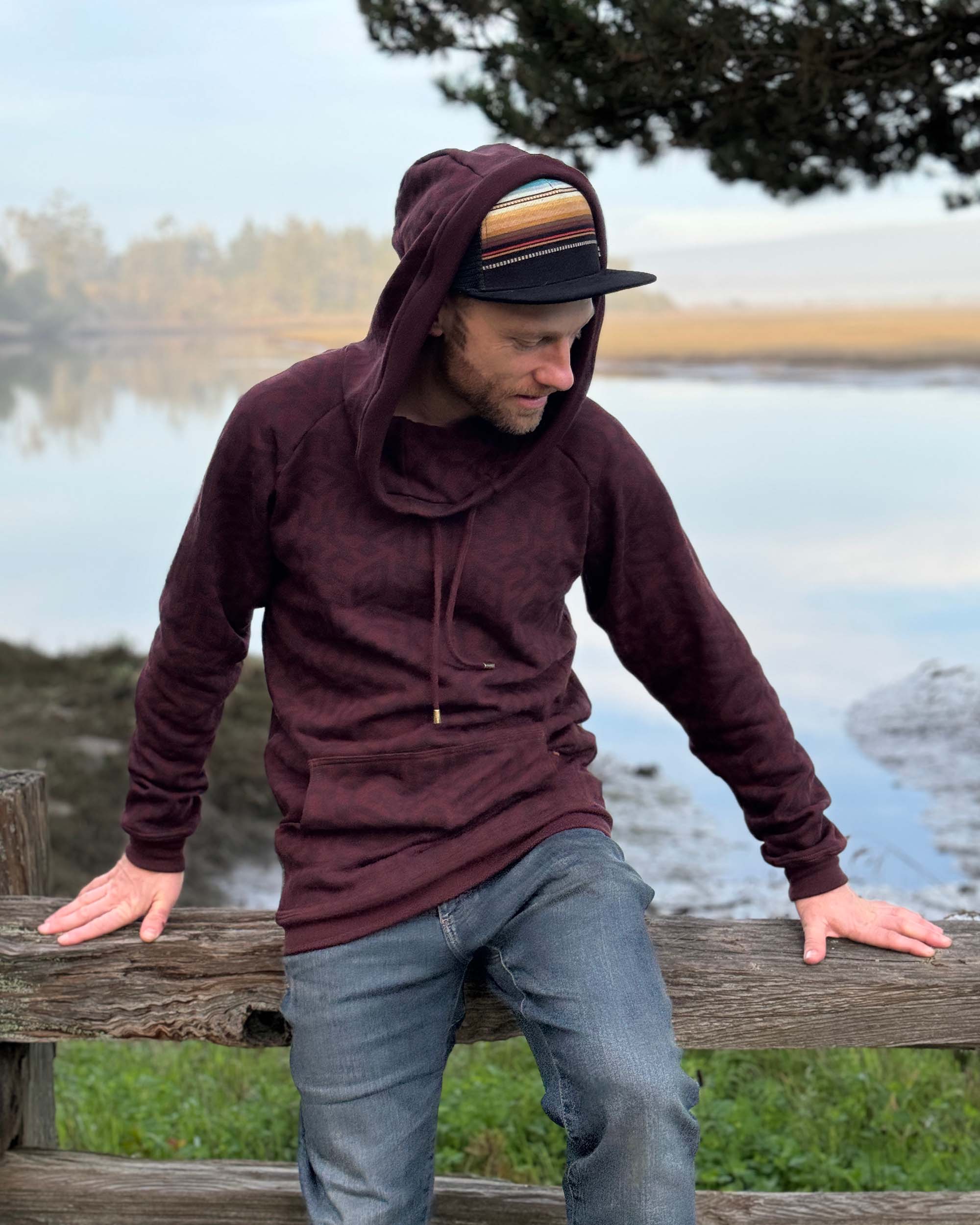 Organic cotton fleece unisex hoodie, reddish brown fabric with geo print, front view on male model.