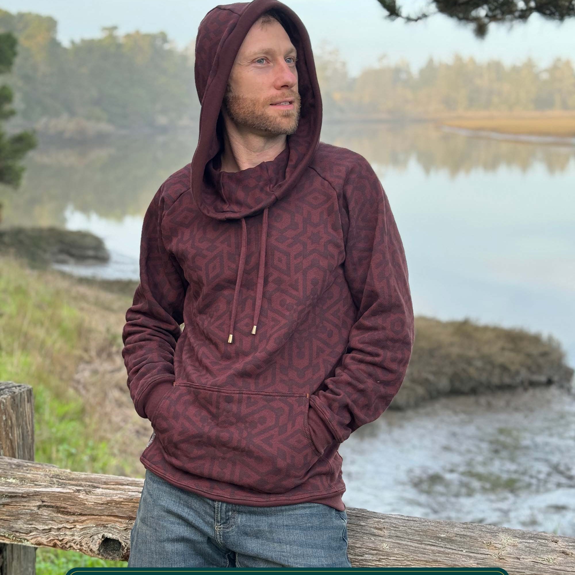 Organic cotton fleece unisex hoodie, reddish brown fabric with geometric print, front side view on male model.