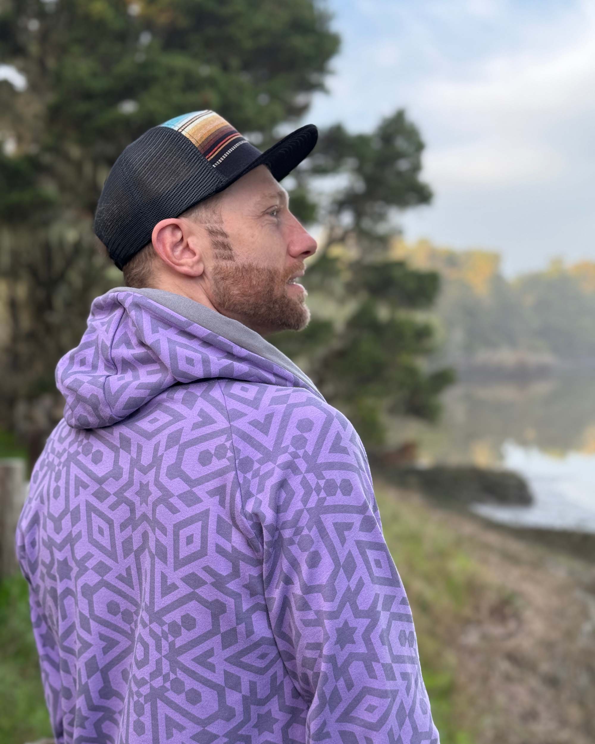 Organic cotton extra long unisex hoodie, lavender with sacred geometry print, back view of male model.