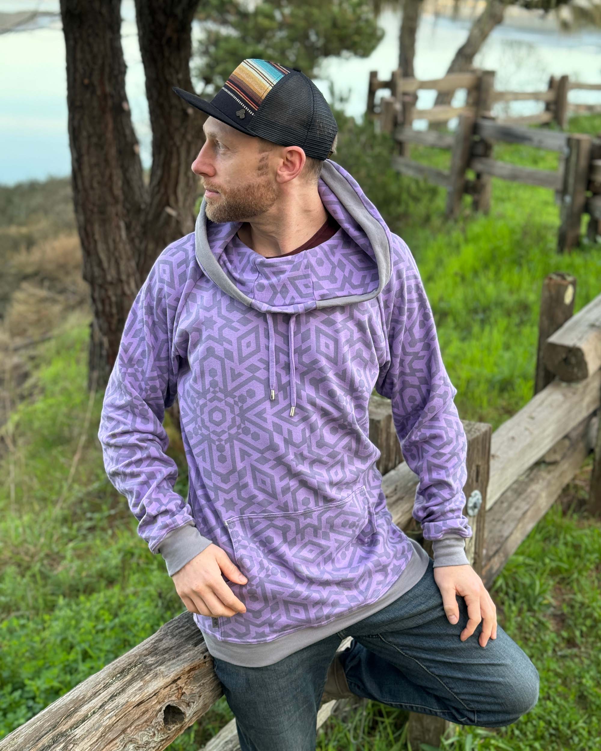 Organic cotton extra long unisex hoodie, lavender with geo print, left side view of male model.
