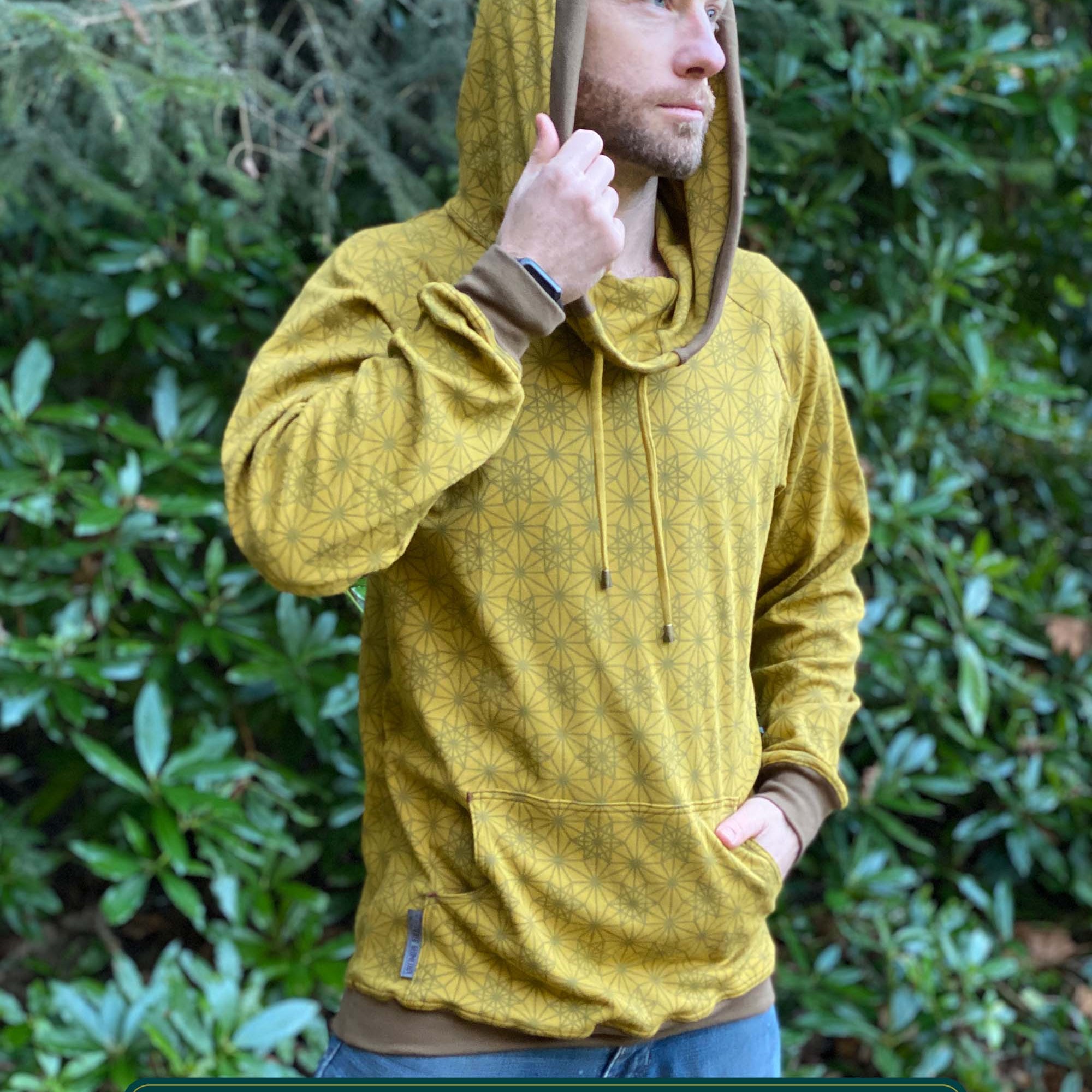 Organic cotton extra long unisex hoodie, yellow fabric with geometric print, right side view of male model.