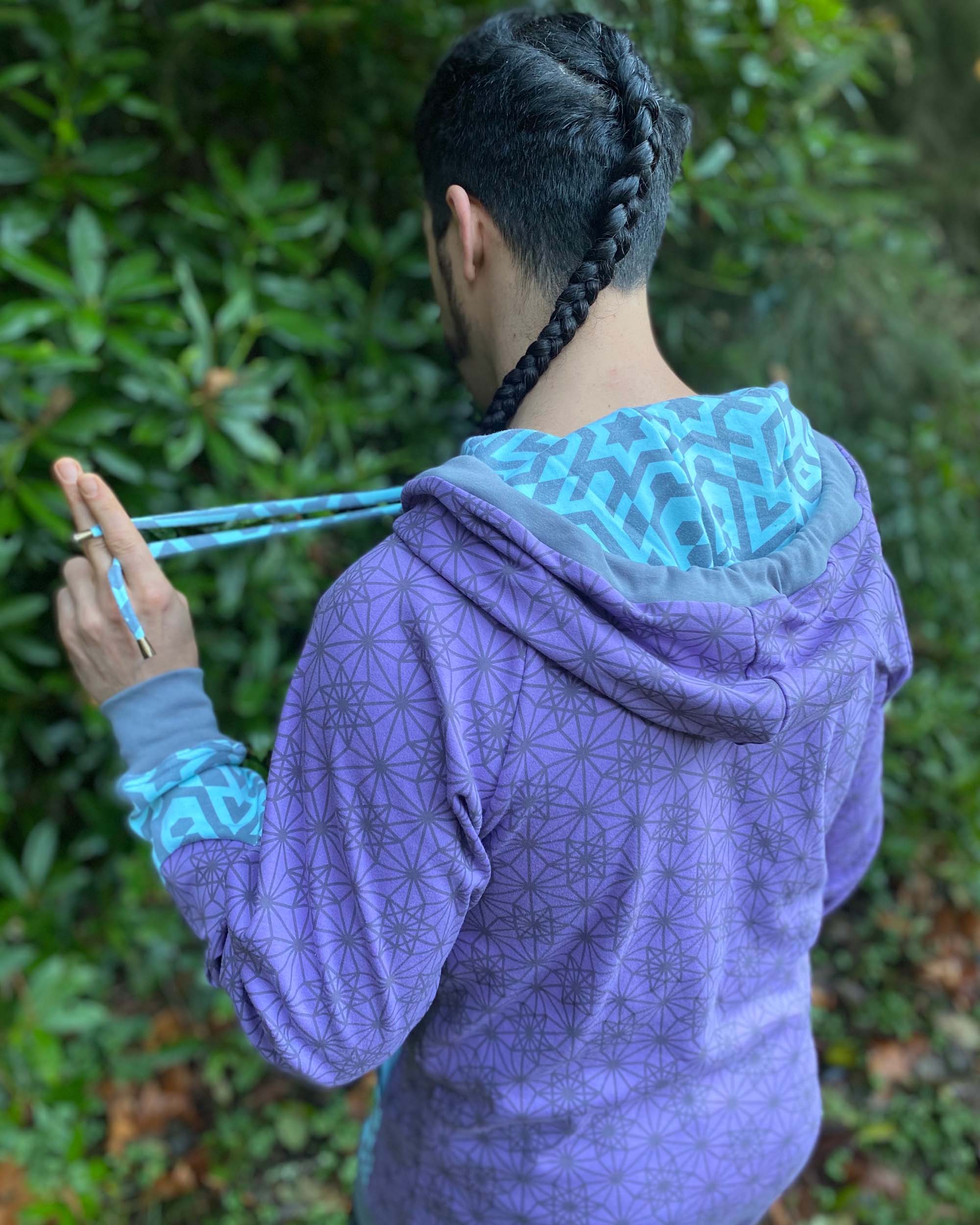 Organic cotton hoodie, lavender fabric with geometric print, back side view on male model.