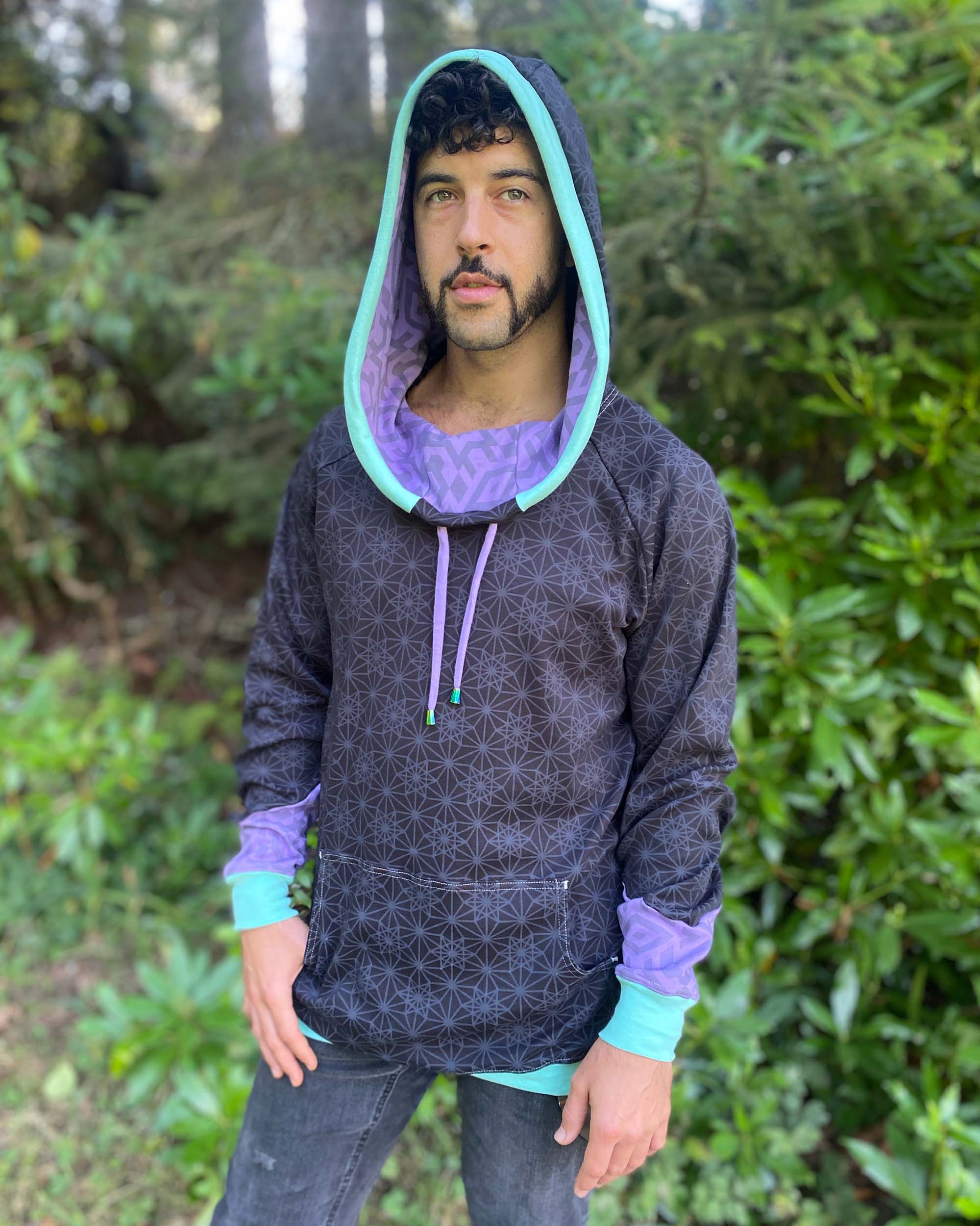 Organic cotton hoodie, black with geometric print, front view worn by male model.