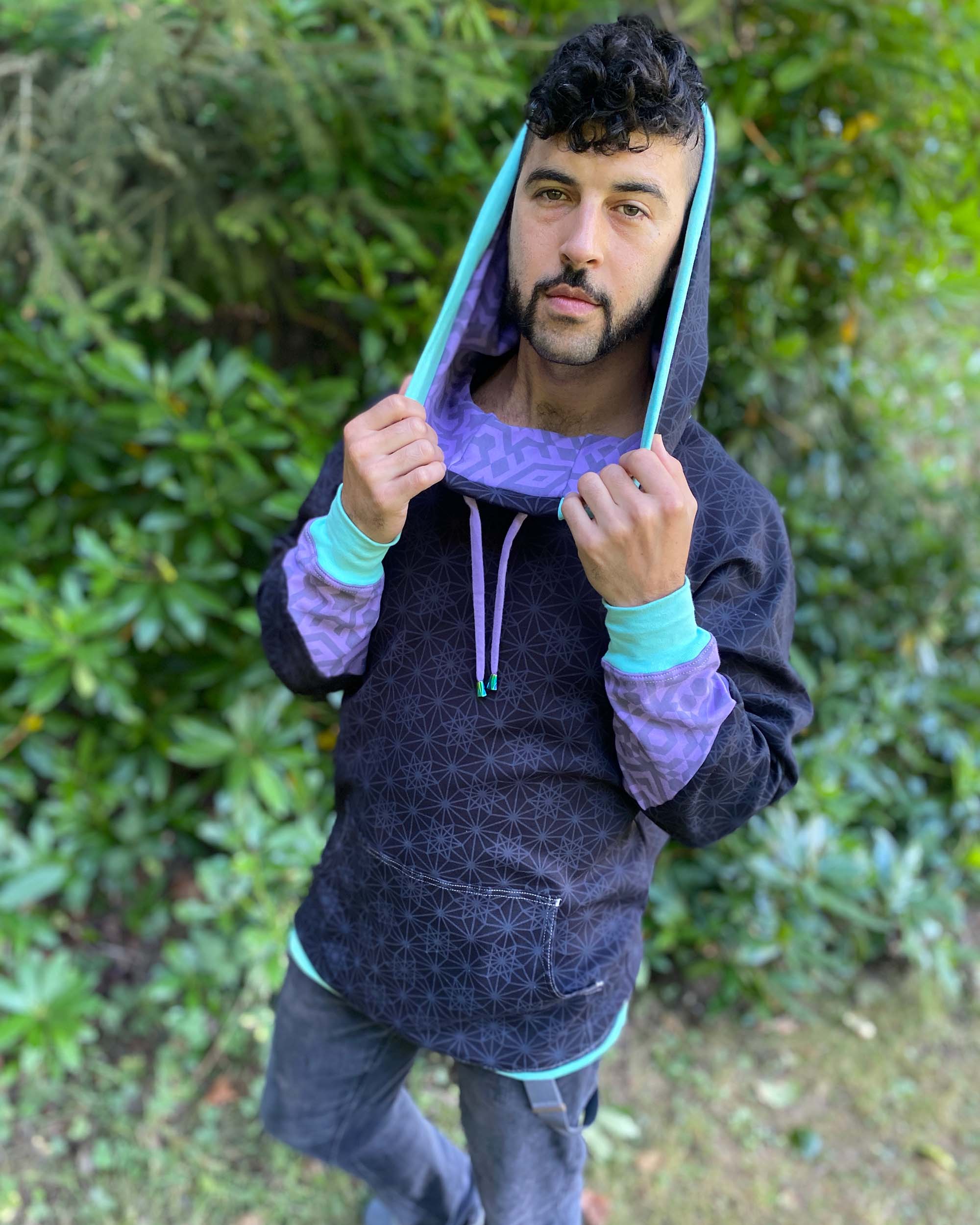 Organic cotton hoodie, black with geo print, front view worn by male model.