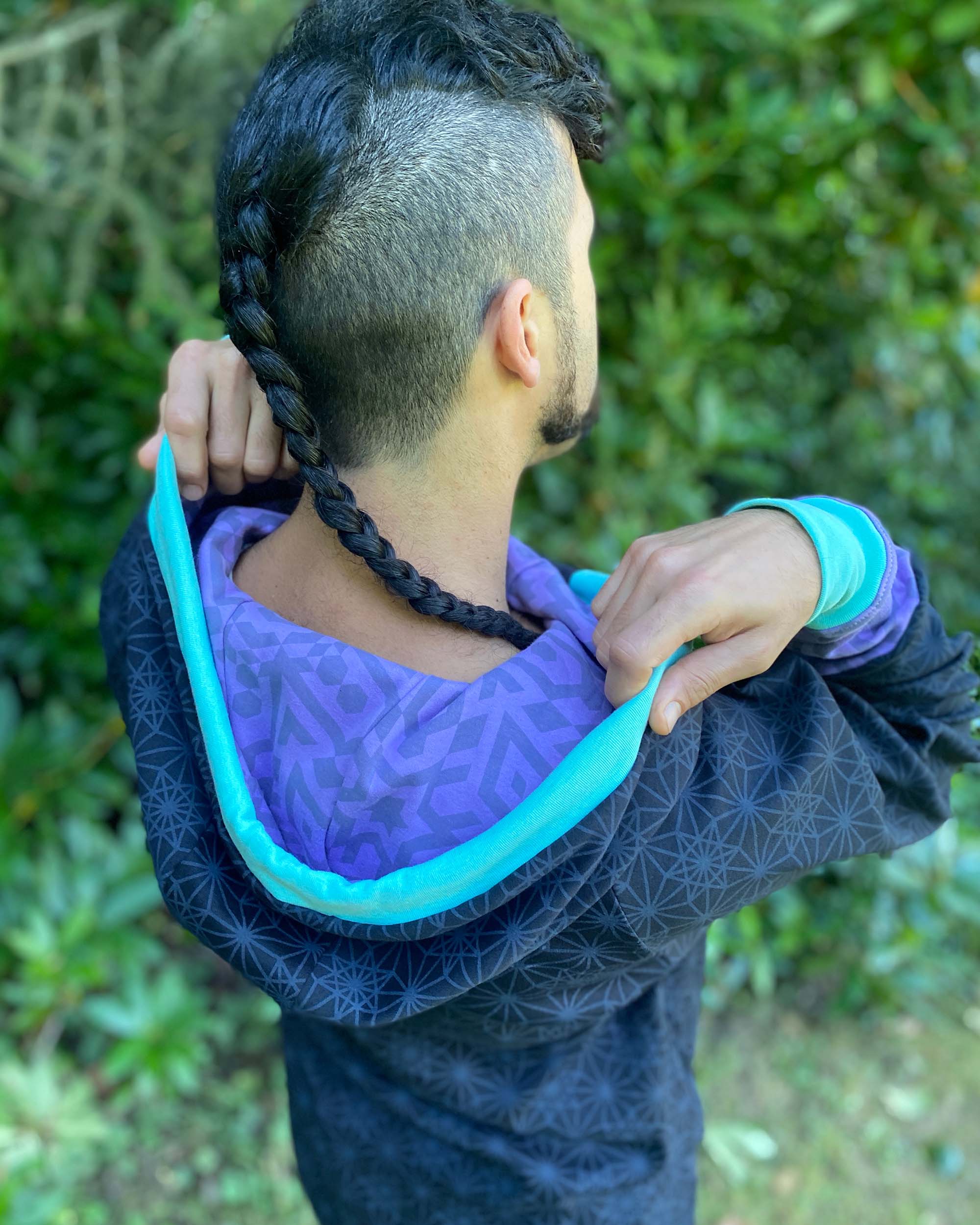 Organic cotton hoodie, black with sacred geometry print and lavender accents, back side view of hood.