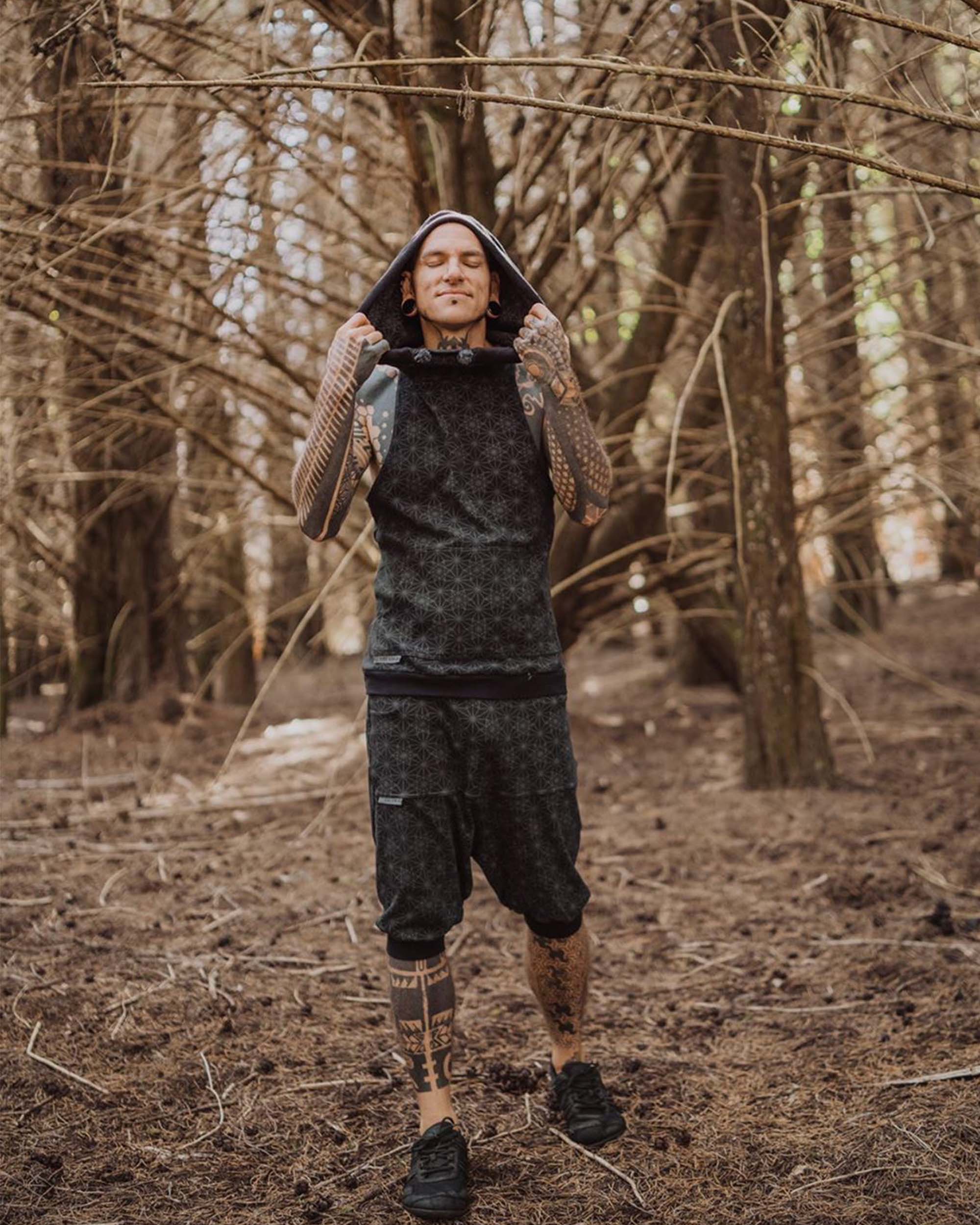 Organic cotton sleeveless hoodie, black with geometric print, front view on male model.