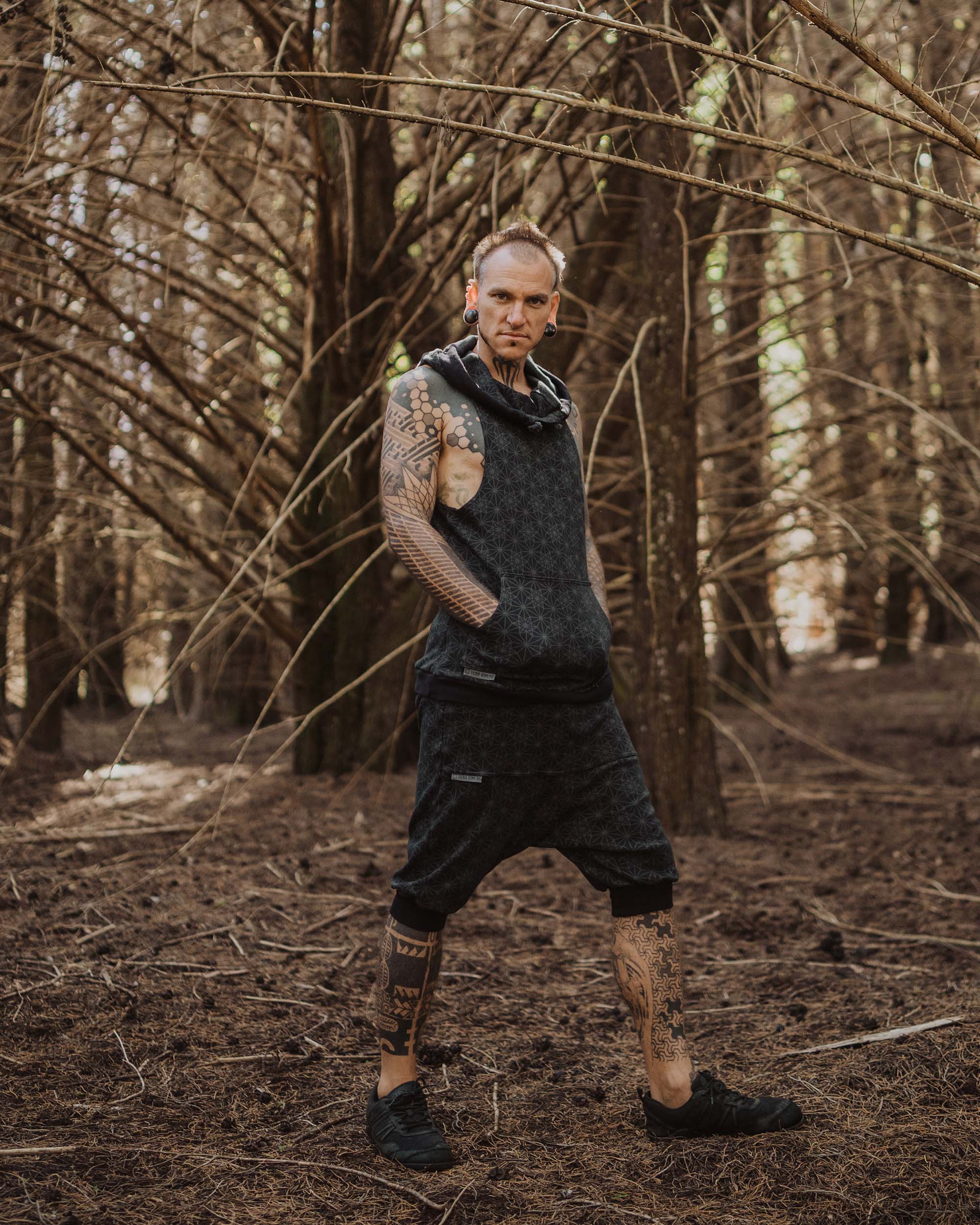 Organic cotton sleeveless hoodie, black with sacred geometry print, front right view on male model.