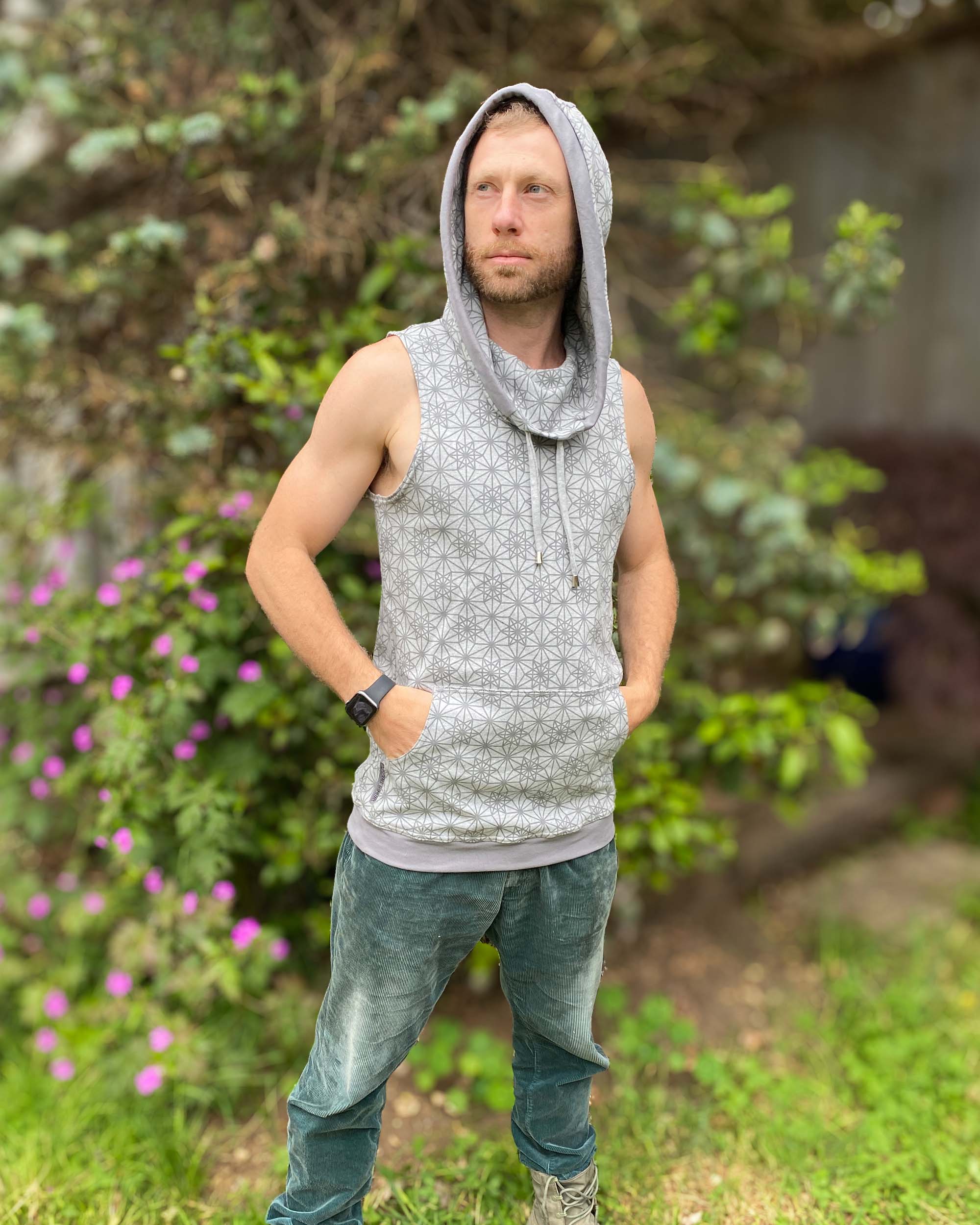Organic cotton sleeveless hoodie, grey with geometric print, front right view on male model.