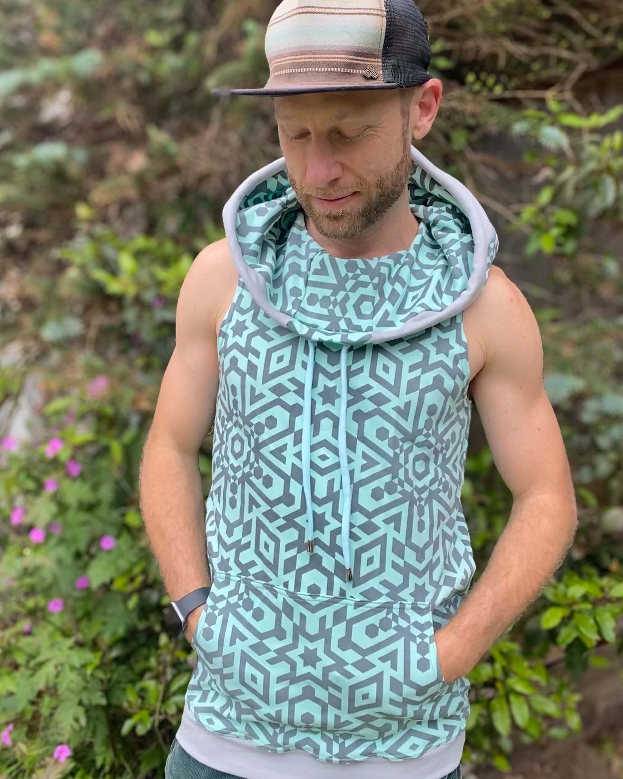 Organic cotton sleeveless hoodie, mint with geo print fabric, front view on male model.