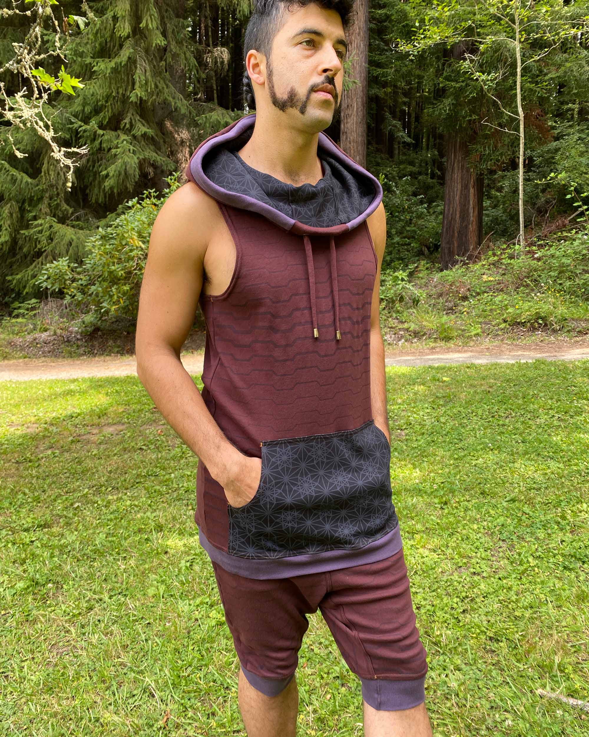 Organic cotton hooded tank top, brown with black accents and geometric print, front right on male model.