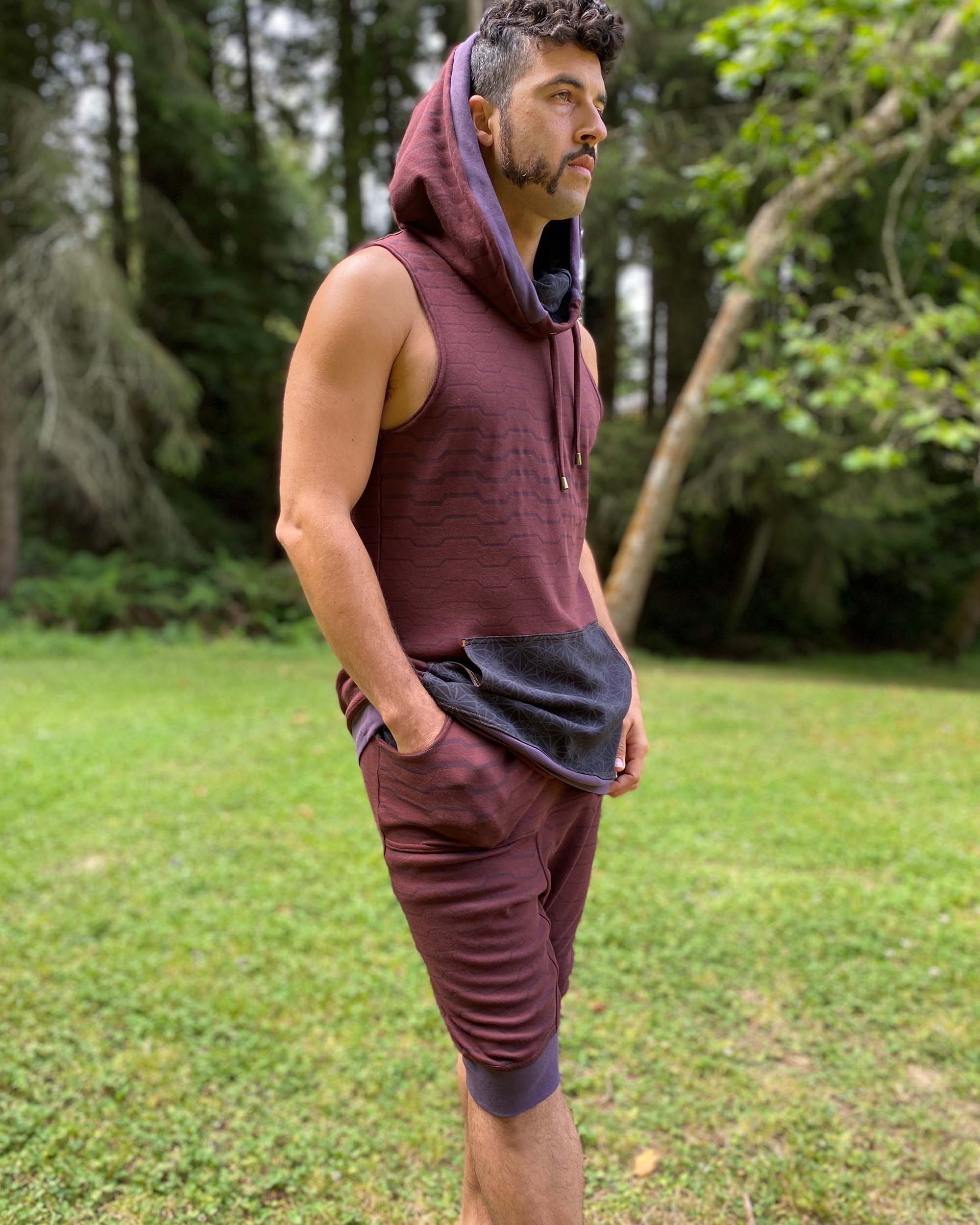 Organic cotton hooded tank top, brown with black accents and geometric print, right side view on male model.