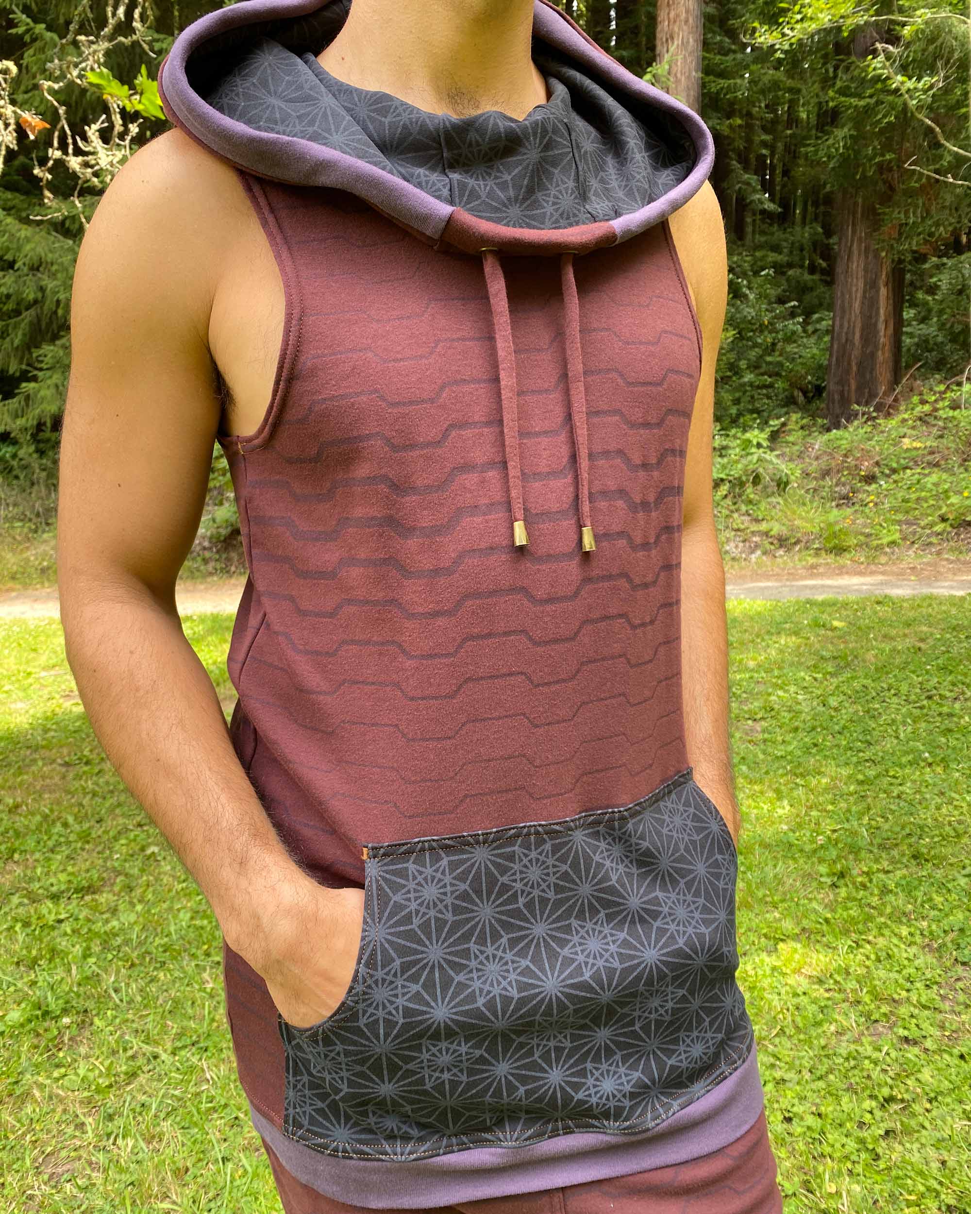 Organic cotton hooded tank top, brown with black accents and geometric print, front close up view of fabric.